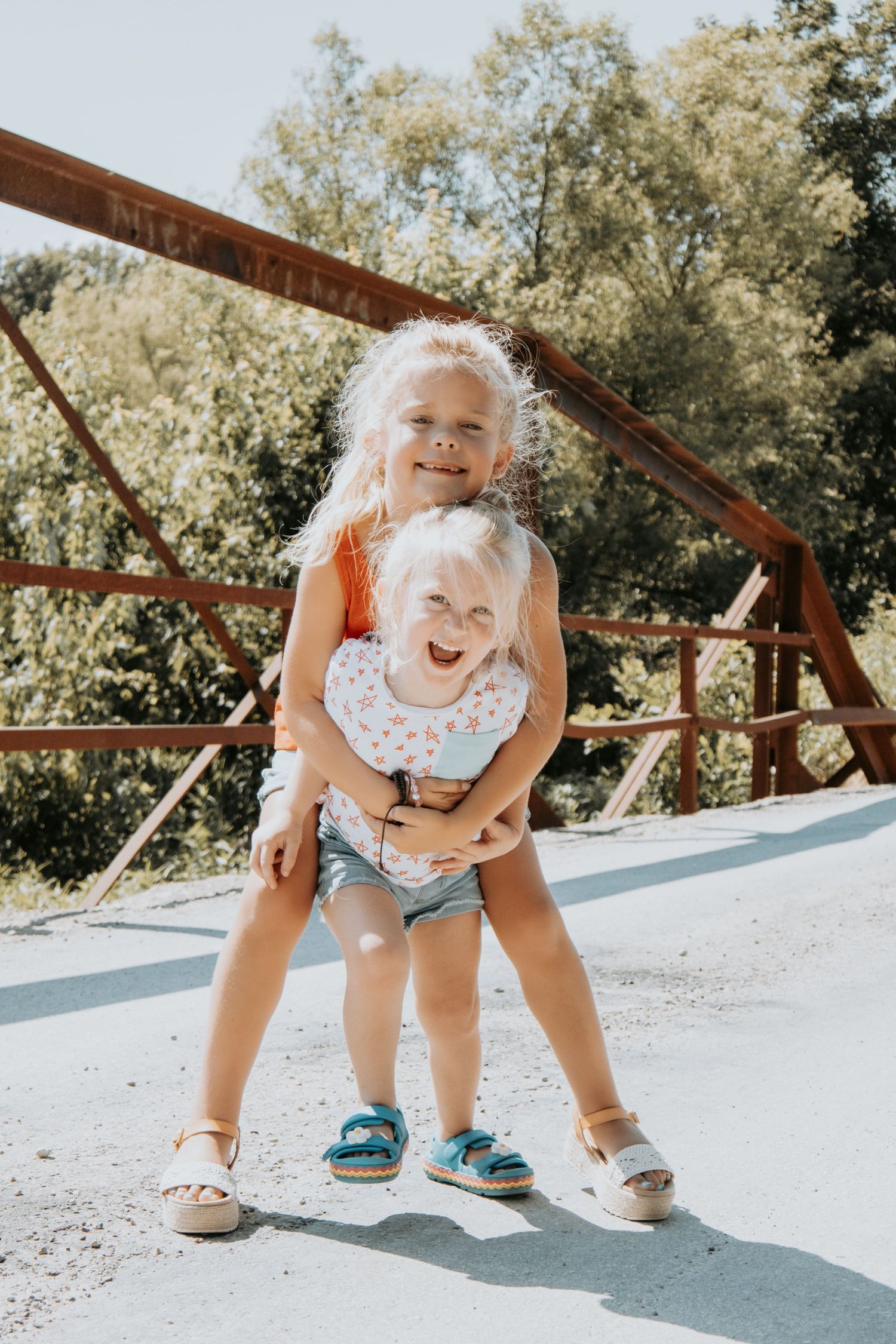 A child bends down close to a bridge deck on a sunny day, shown in a creative sequence of playful poses.