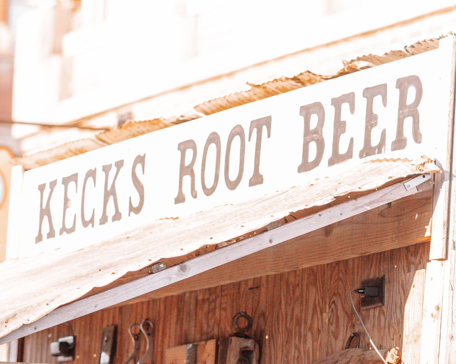 Vintage wooden storefront signs advertising root beer in sepia tones.