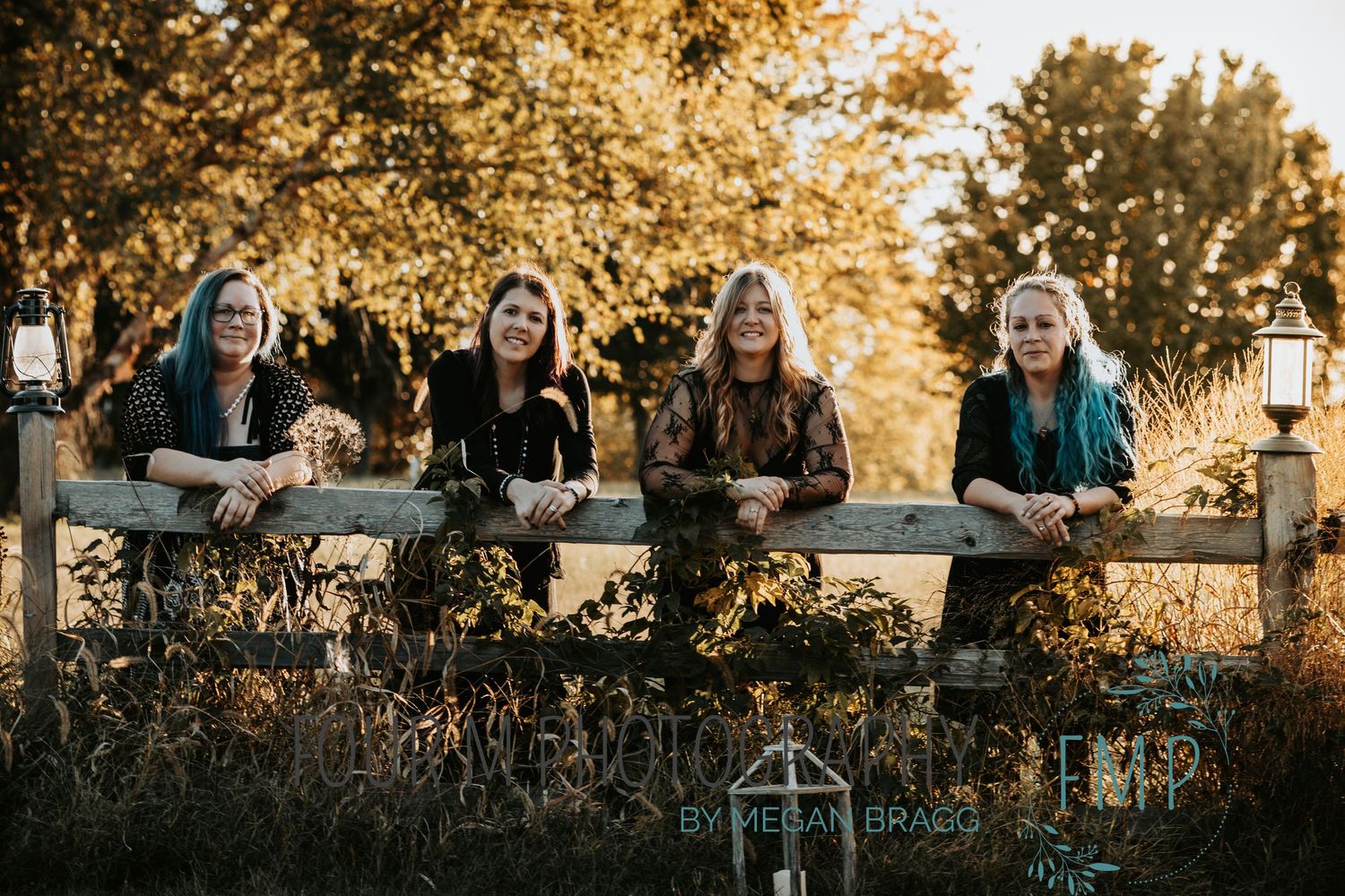 A group of people sitting together outdoors during golden hour with warm autumn sunlight filtering through trees.