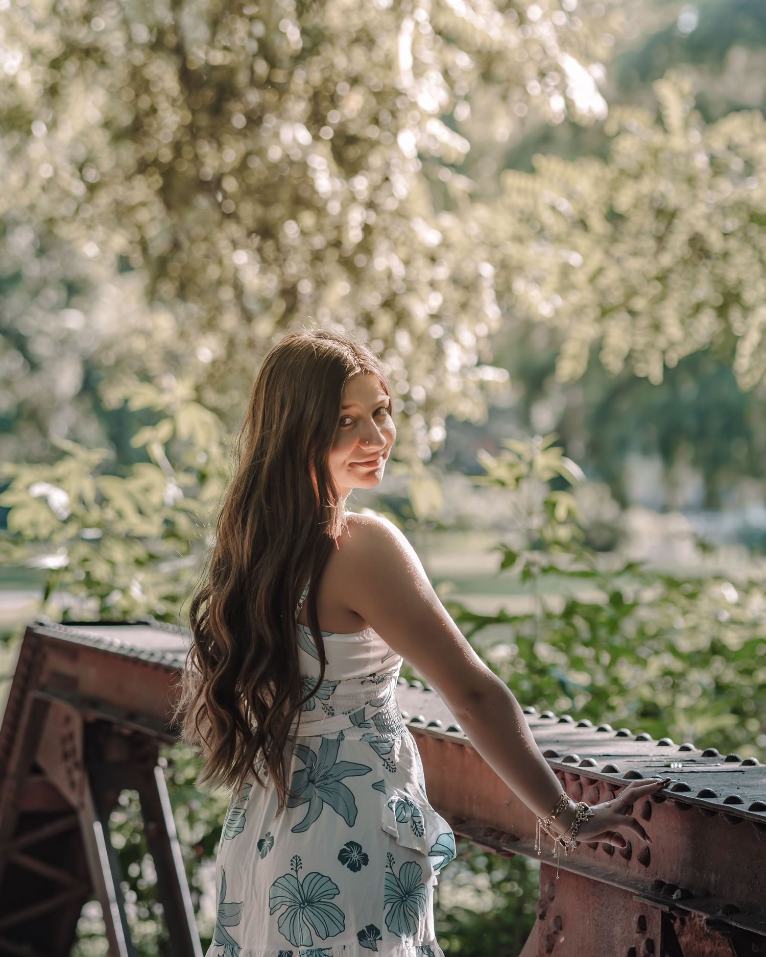 A floral sundress contrasts beautifully with rustic wooden furniture in dappled sunlight.