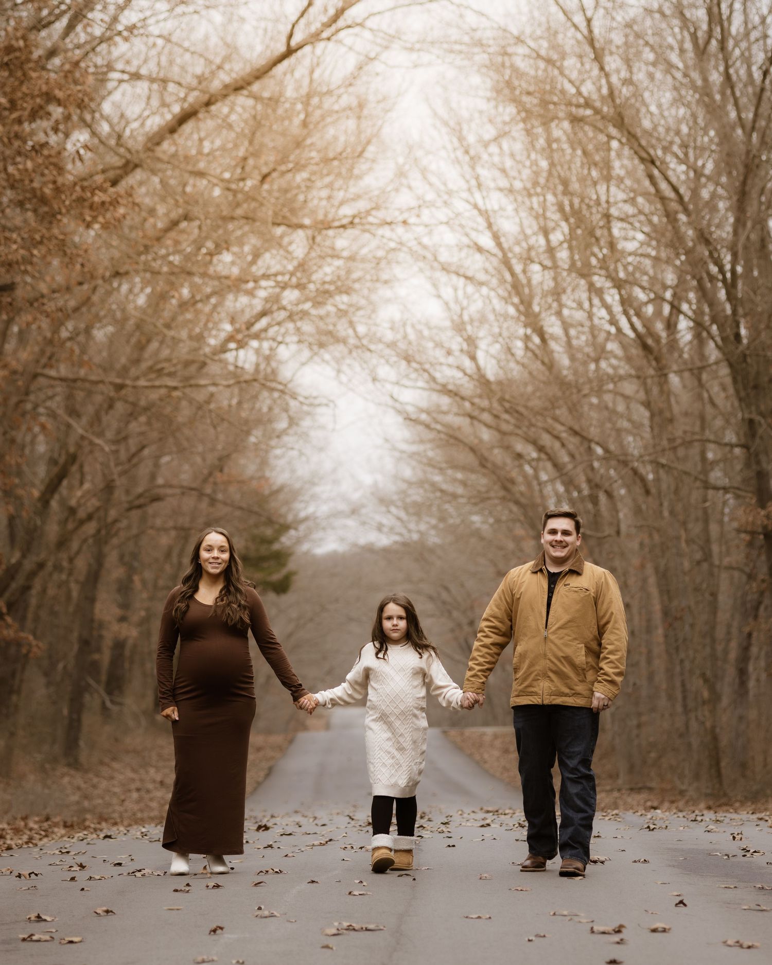 Creative family photo series showing people peeking out from behind trees in a misty autumn forest.