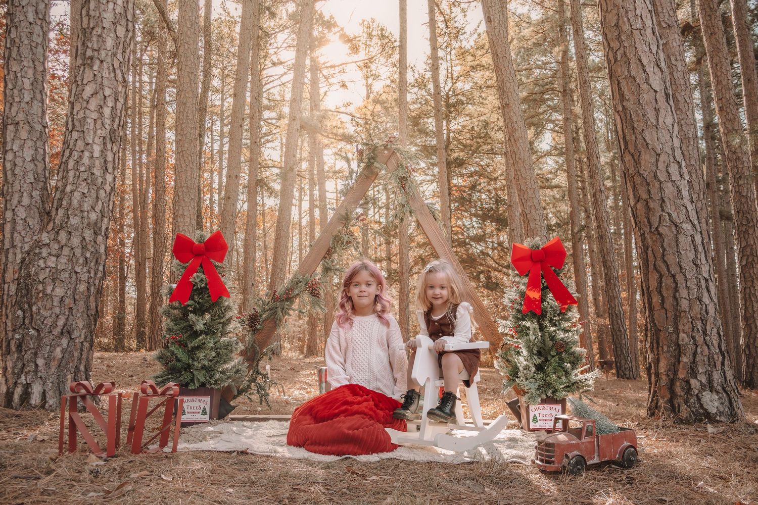 A magical winter forest scene with red accents and rustic decor creates a festive holiday atmosphere in the woods.