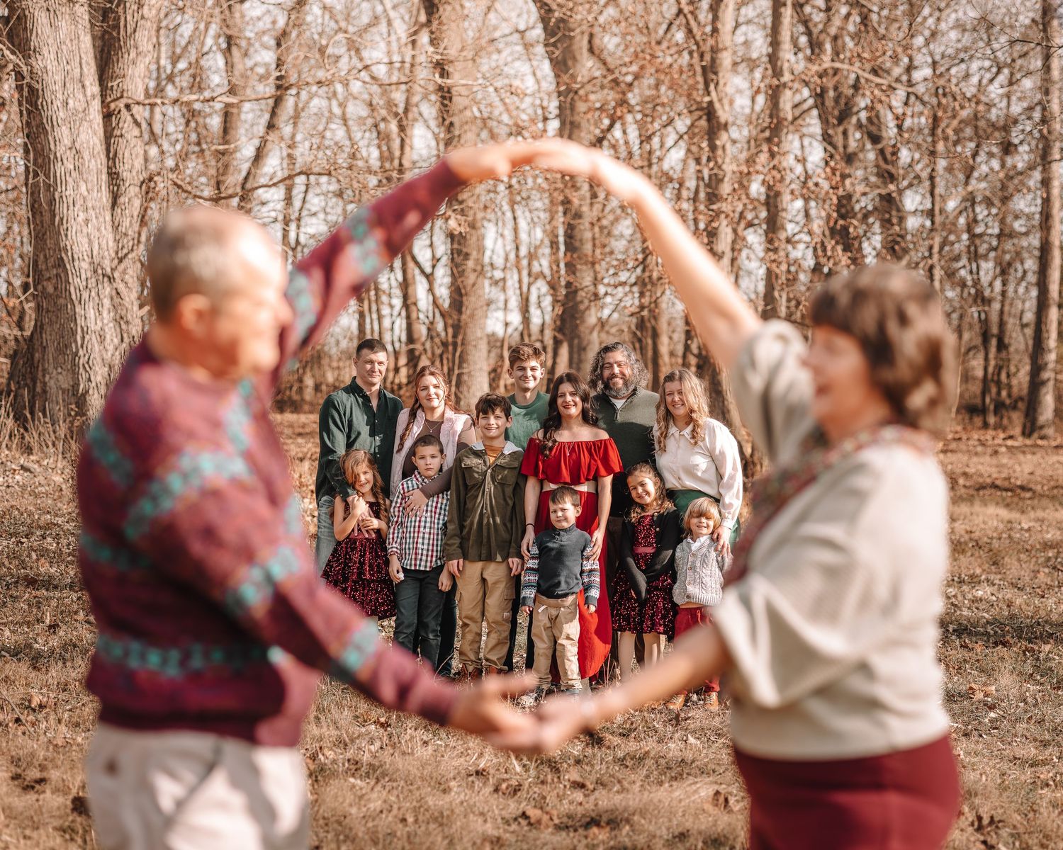 A couple dances together in a wooded area during autumn, creating a romantic and whimsical outdoor scene.