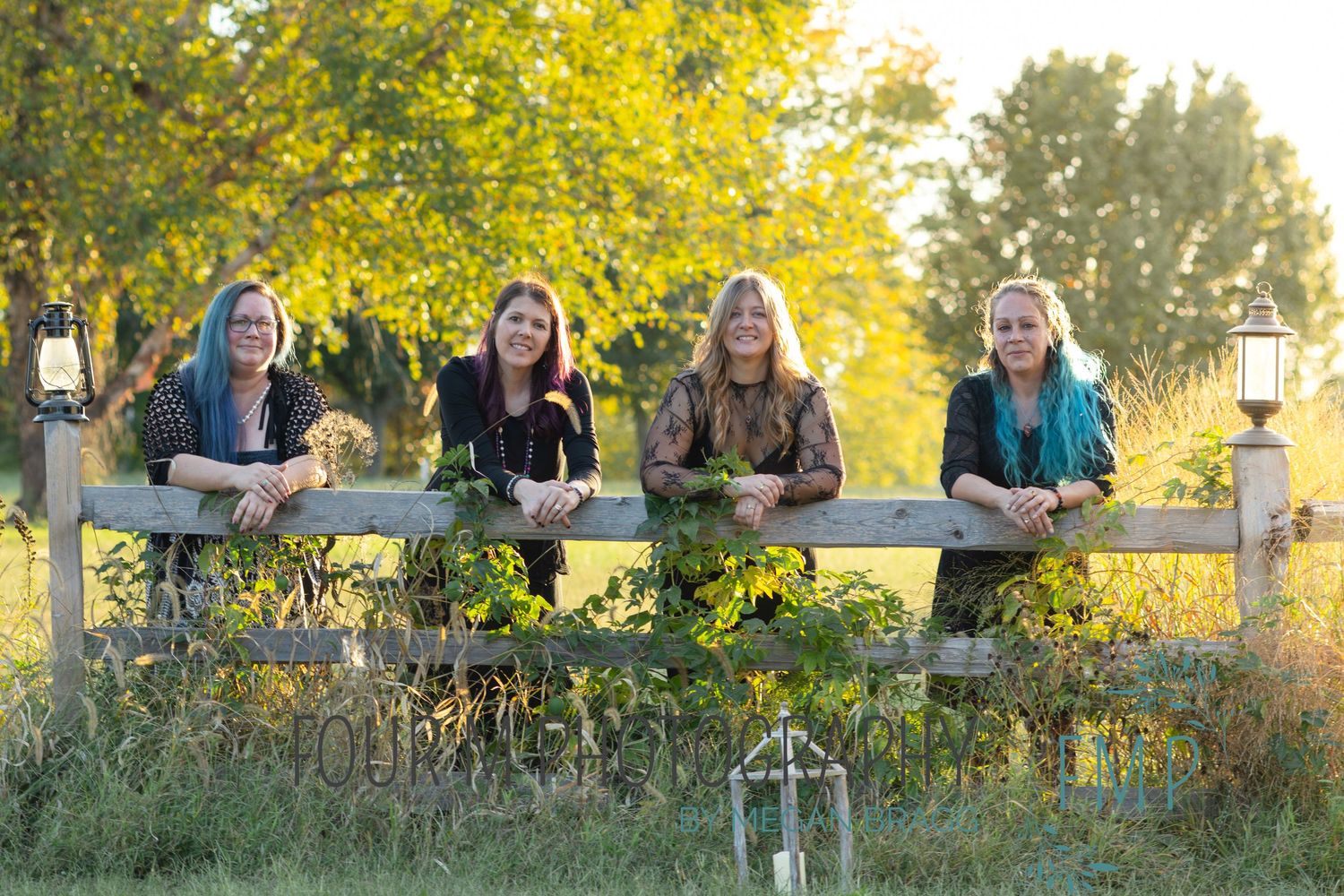 A group of people sitting outdoors on a bench in autumn with golden yellow trees in the background.