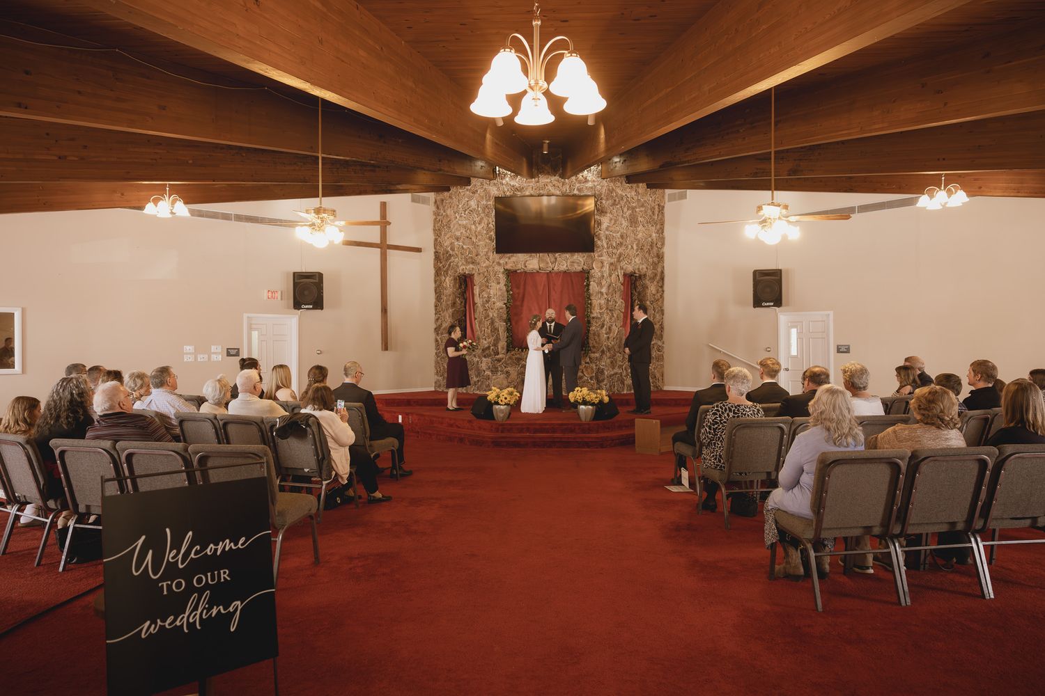 Modern church sanctuary with red carpet and rows of chairs arranged for worship services.