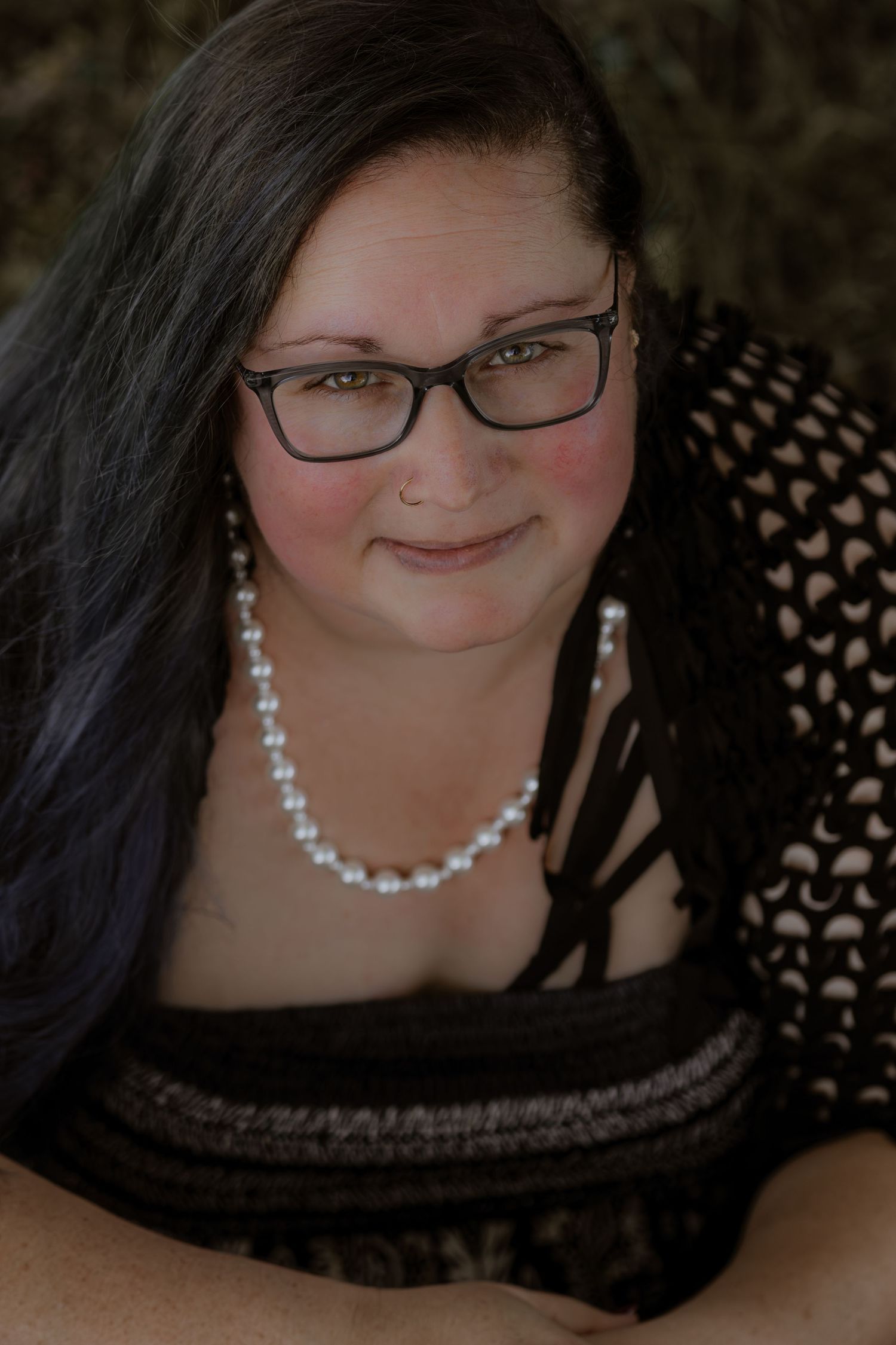 A series of close-up portrait shots showing a person wearing glasses and a pearl necklace against a dark background.