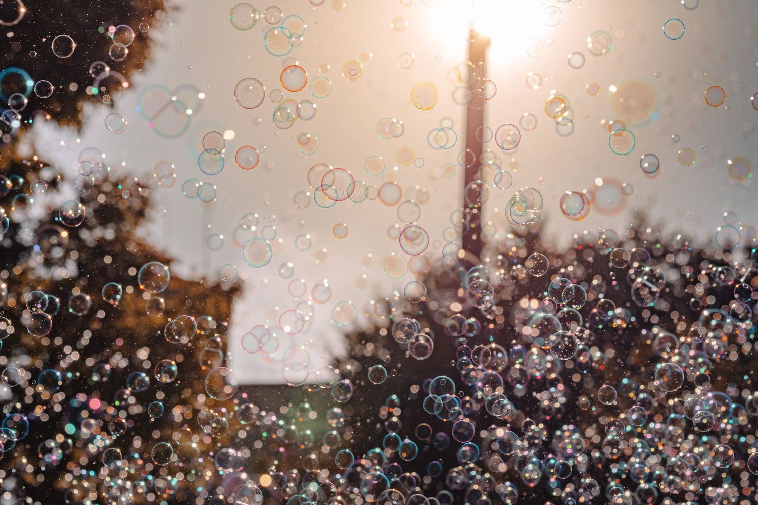 Bubbles floating in the air against a sunset sky creating a magical atmosphere at an outdoor event.