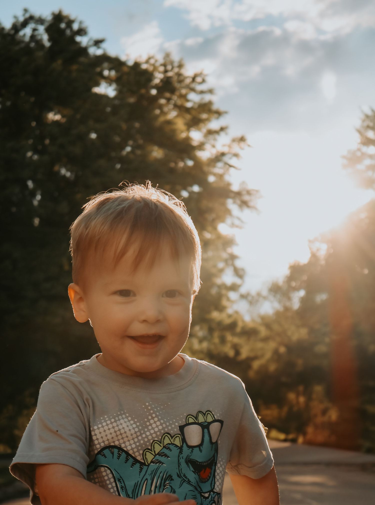 A series of outdoor photos showing a child in light-dappled sunlight wearing a gray t-shirt with a playful expression.