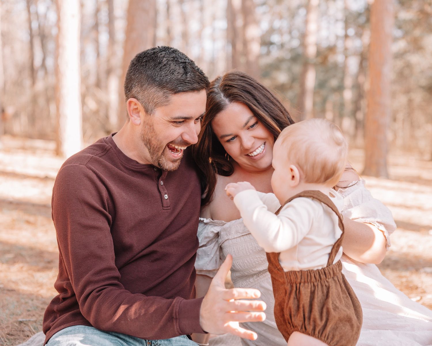 A happy family moment captured outdoors with autumn trees in background.