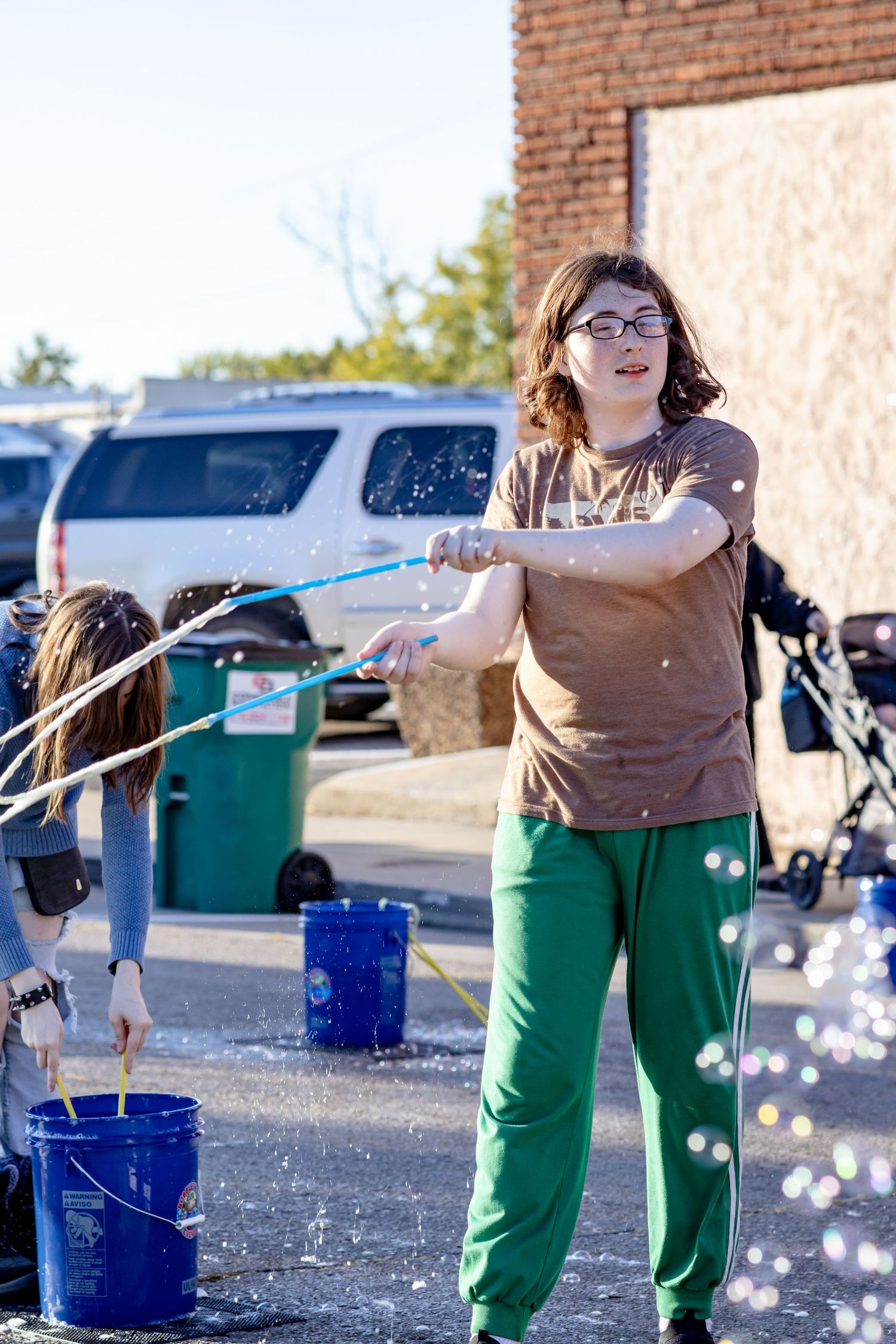 A sequence of photos showing someone splashing water from a blue bucket in an outdoor setting.
