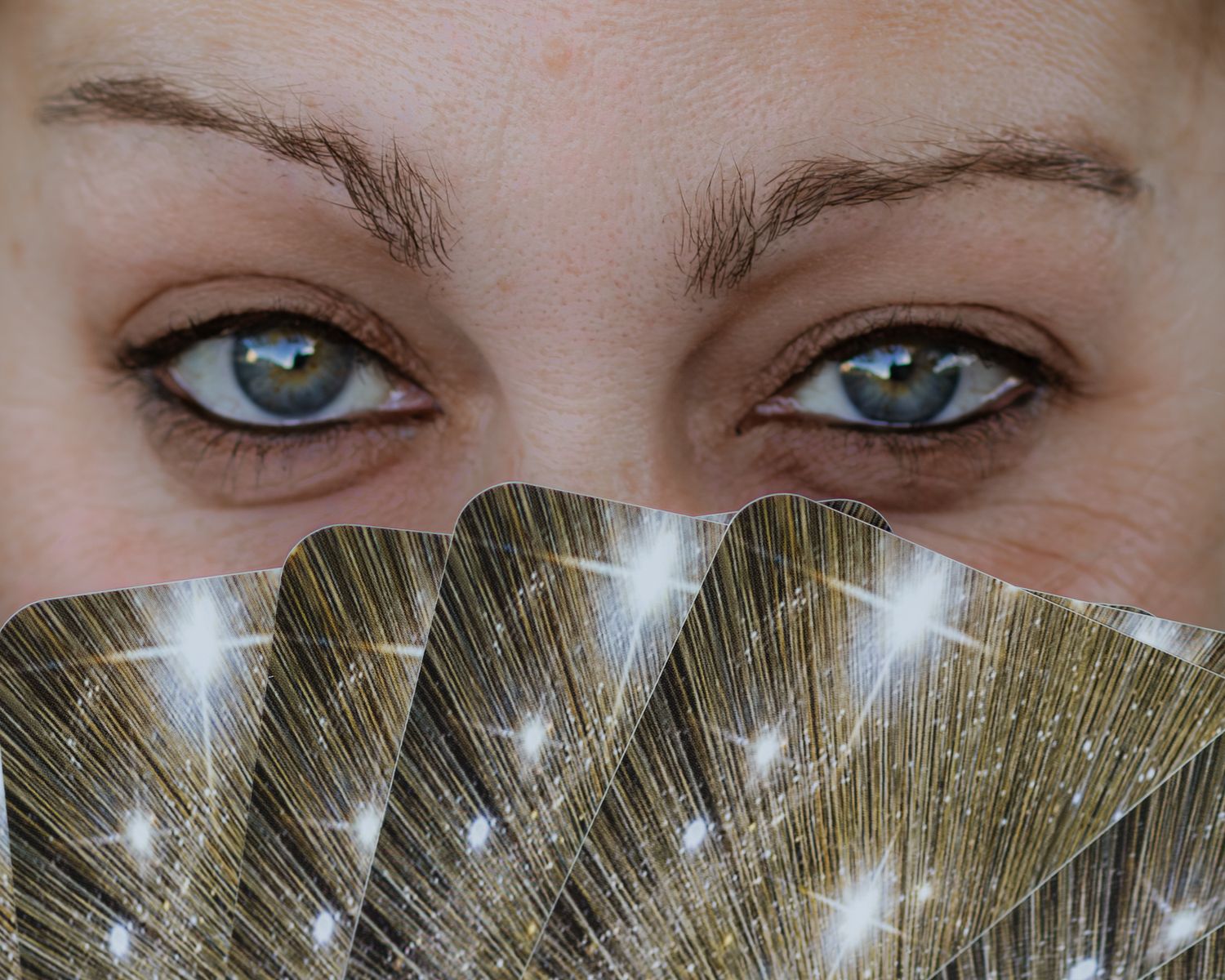 A close-up macro photograph of striking blue eyes with long eyelashes against a light background.