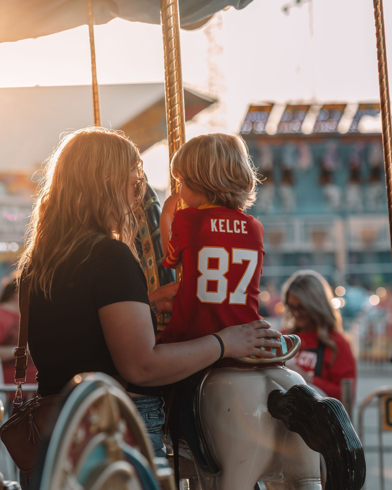 Spectators watching a sports event from stadium seats during sunset.
