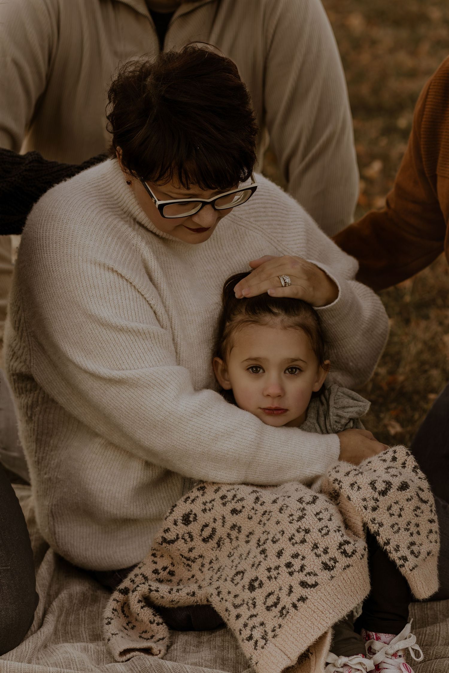 Intimate family moments captured in sepia tones showing gentle embraces and cuddles.