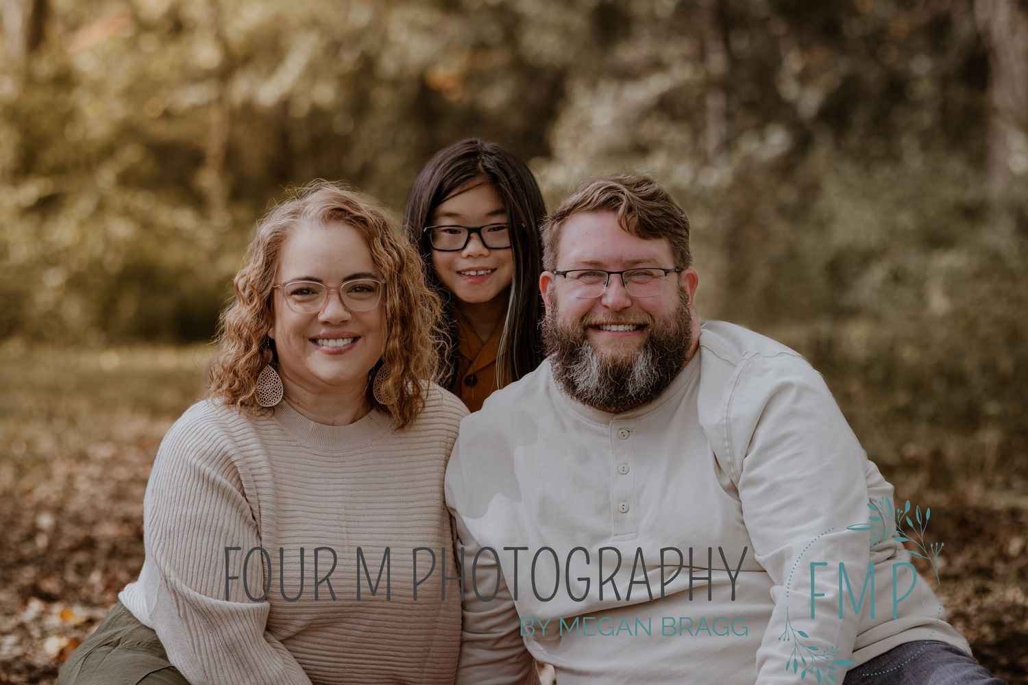 A warm autumn outdoor family photo session with people sitting together in casual attire.