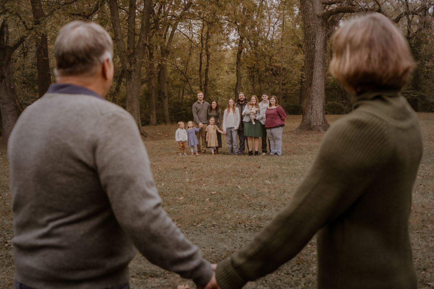 A series of candid outdoor family photos captured in sequence showing people walking together in an autumn forest.