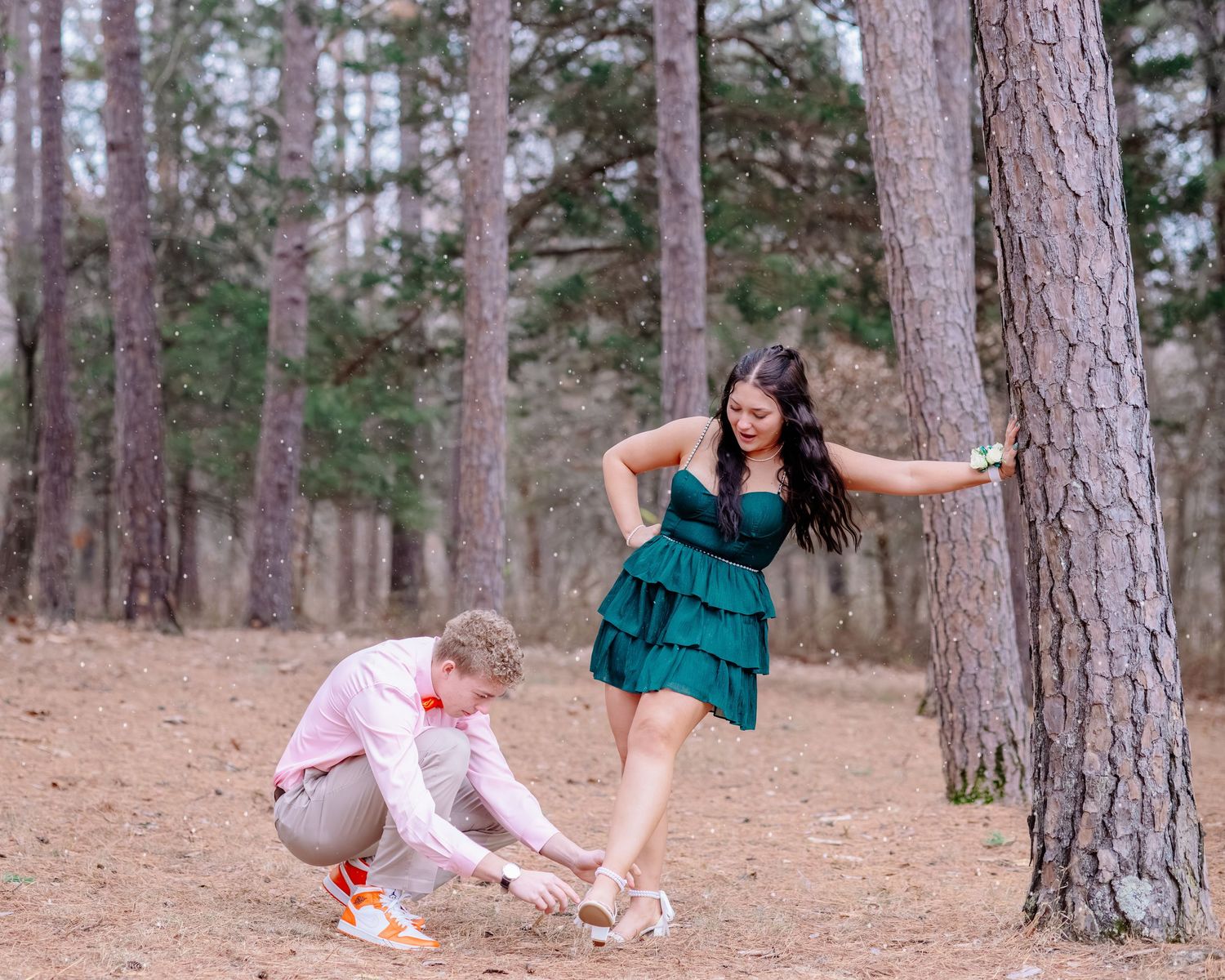 A series of four connected photos showing playful moments in a pine forest setting with green and pink outfits.