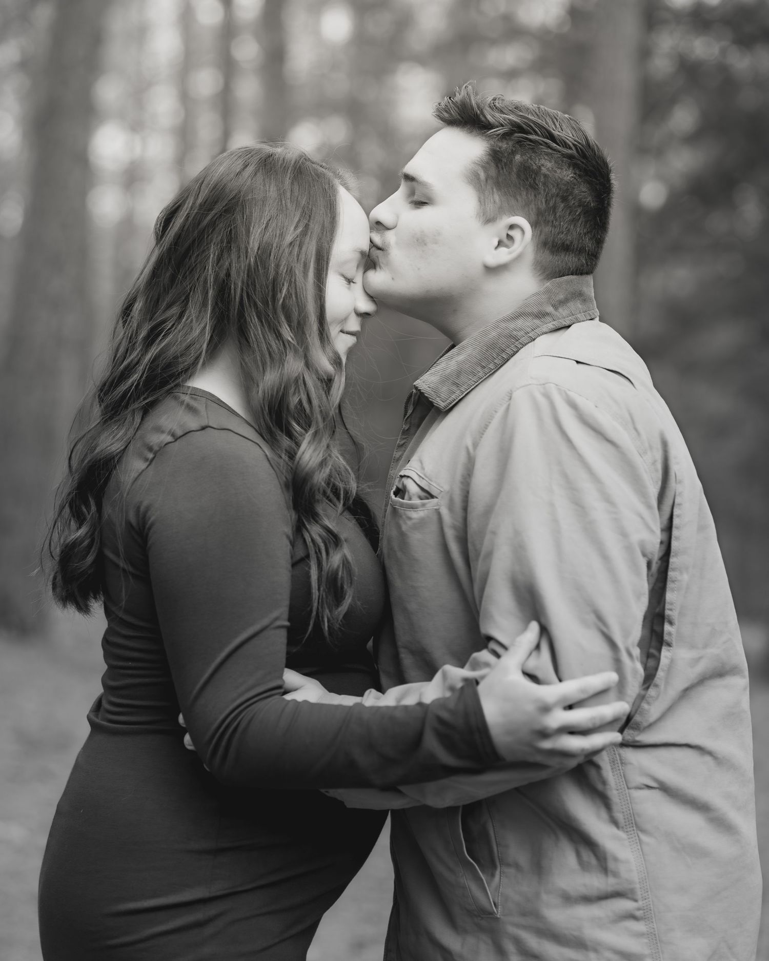 A couple shares an intimate moment in a black and white outdoor photoshoot sequence.