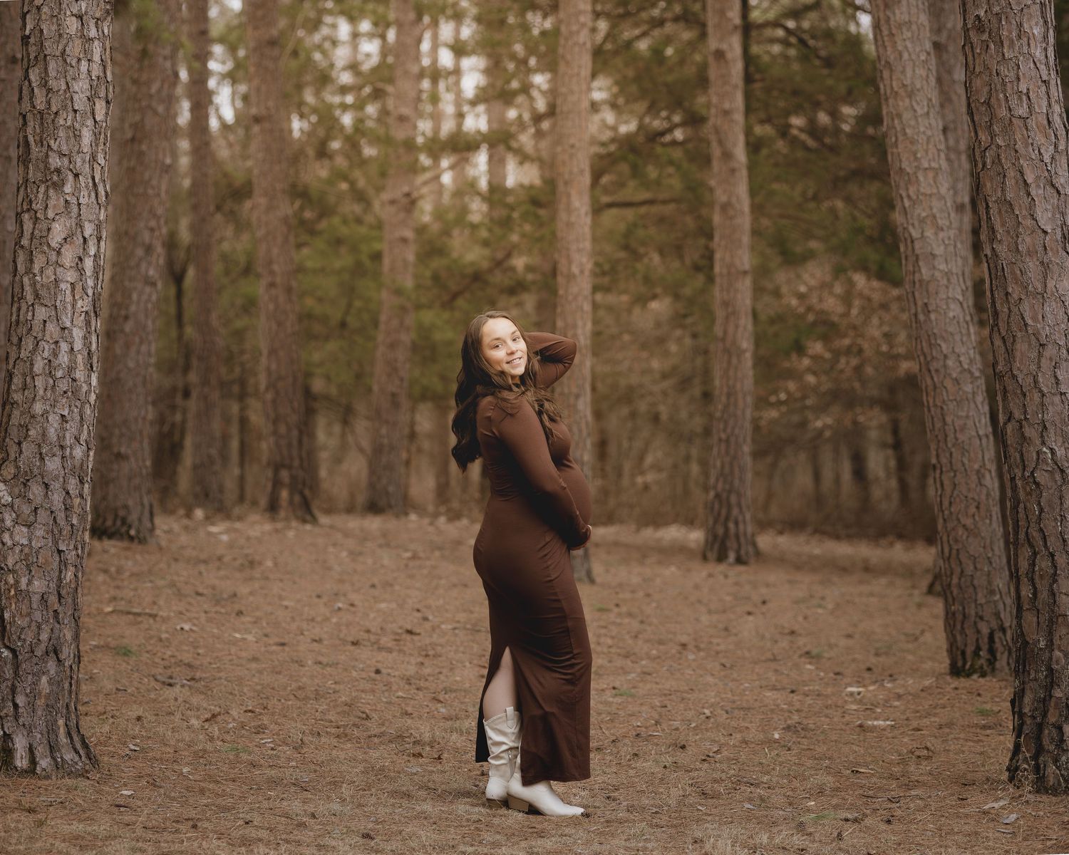 Candid family moments captured in a pine forest with warm earth-toned clothing.