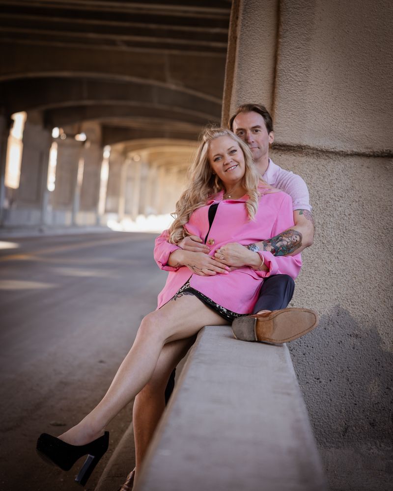 Couple relaxing together in an urban concrete setting with natural lighting.