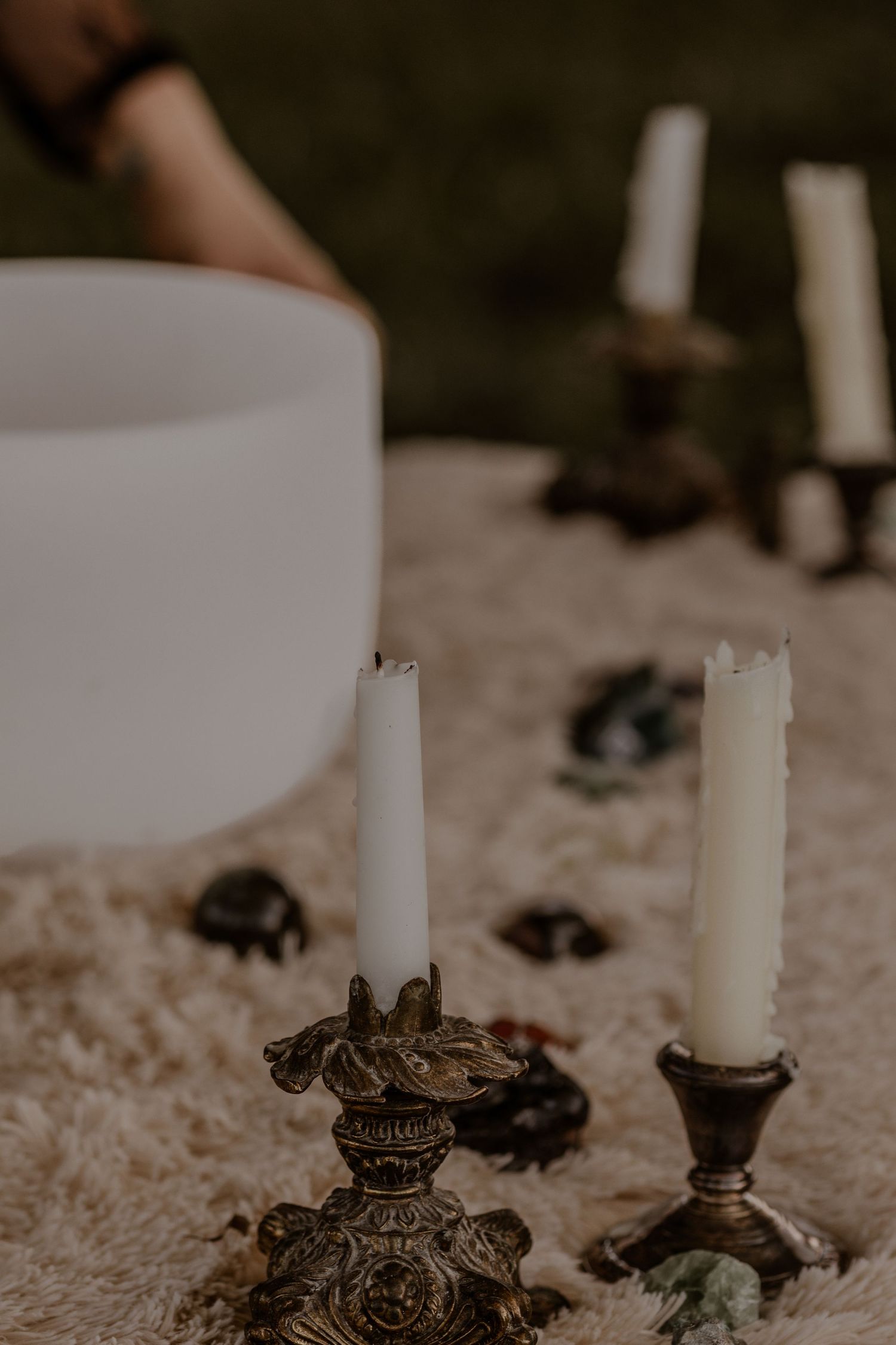 Ornate vintage candlesticks with white candles arranged on a textured surface.