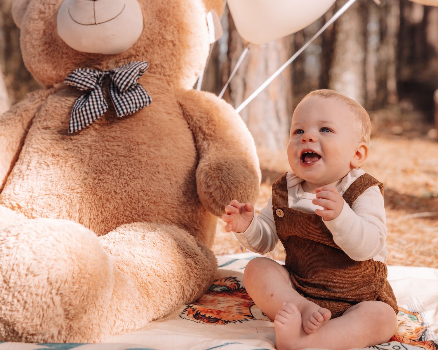 A baby plays with a large brown teddy bear in a series of sepia-toned photos.