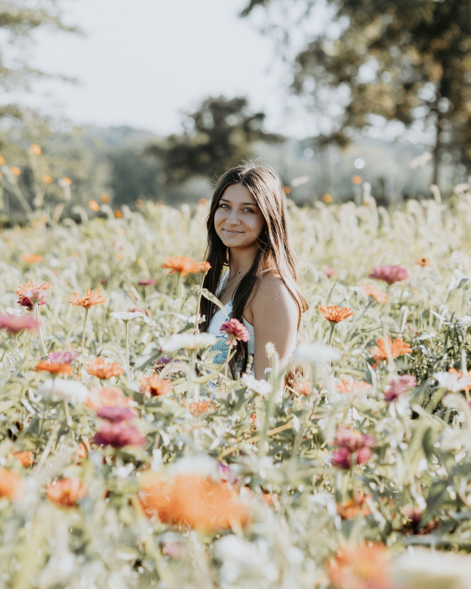 A dreamy portrait photo captured in a blooming wildflower meadow filled with vibrant poppies in soft sunlight.