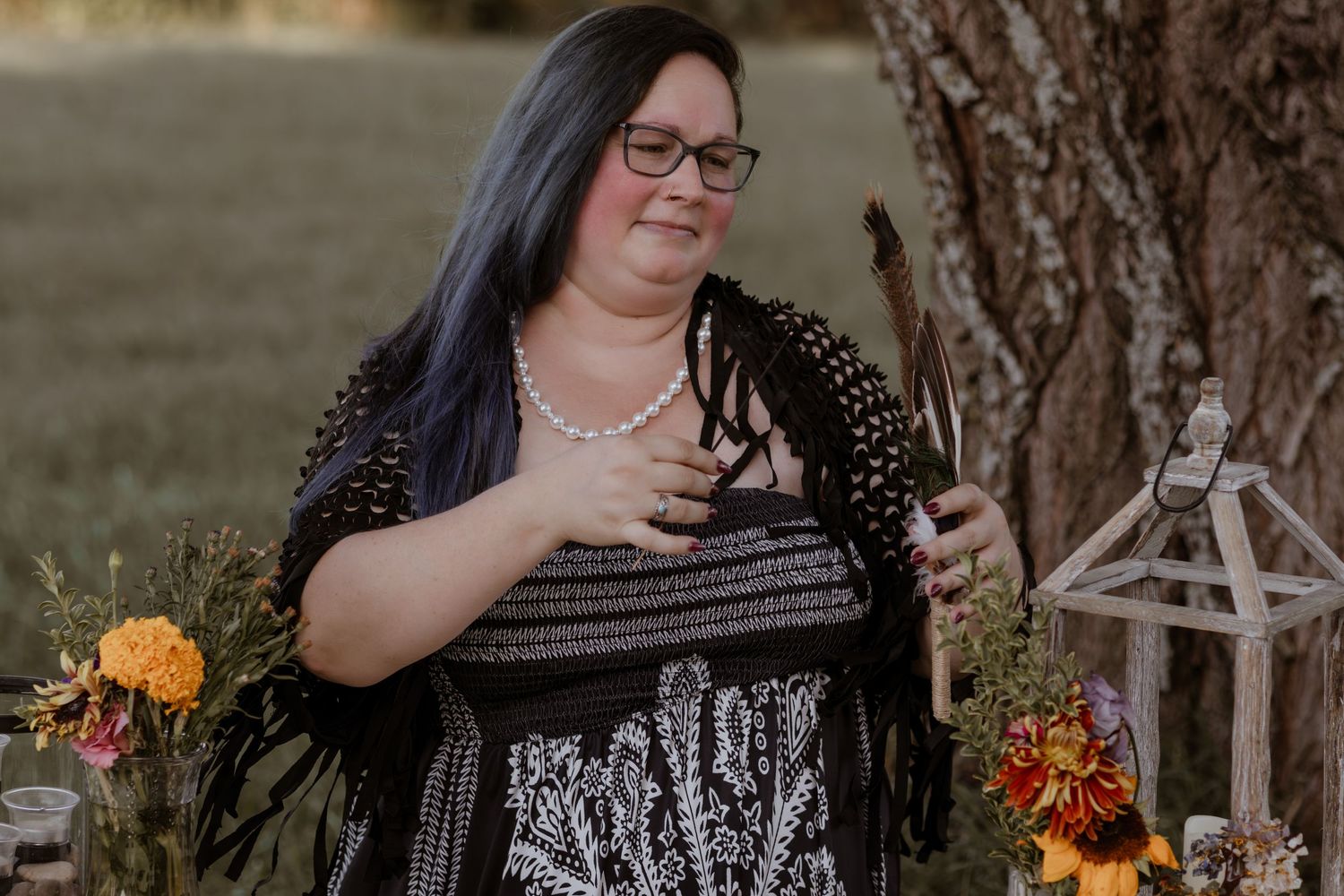 A group of people gathered outdoors wearing dark clothing with autumn decorations.