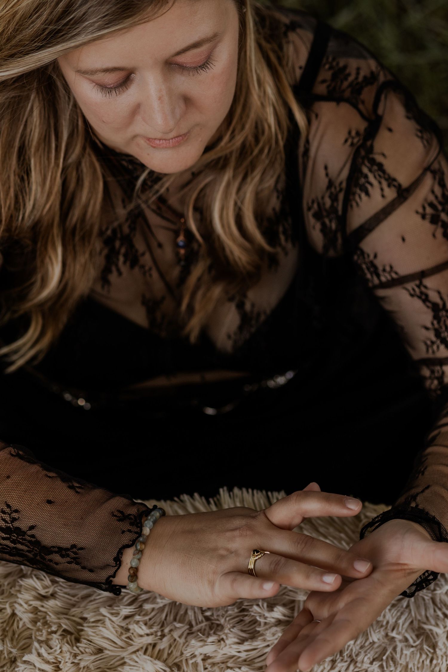 Close-up view of hands gently resting on a textured white surface in warm lighting.