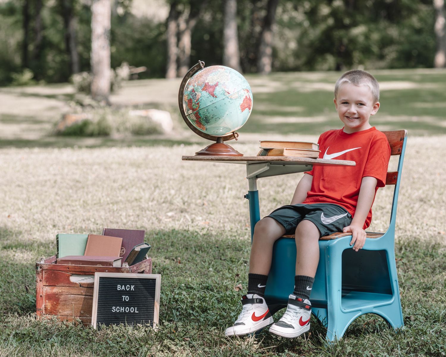A series of back to school photos showing a student with a letterboard and globe on a blue vintage desk outdoors.