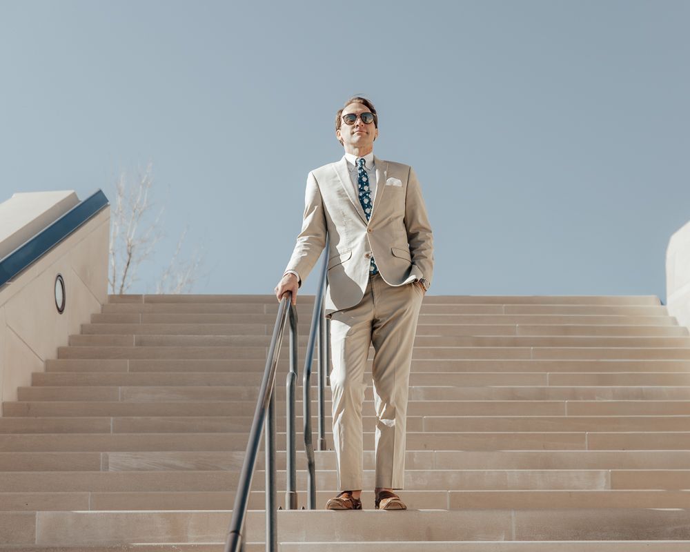 A series of images showing a person in a beige suit walking up concrete steps with a handrail.
