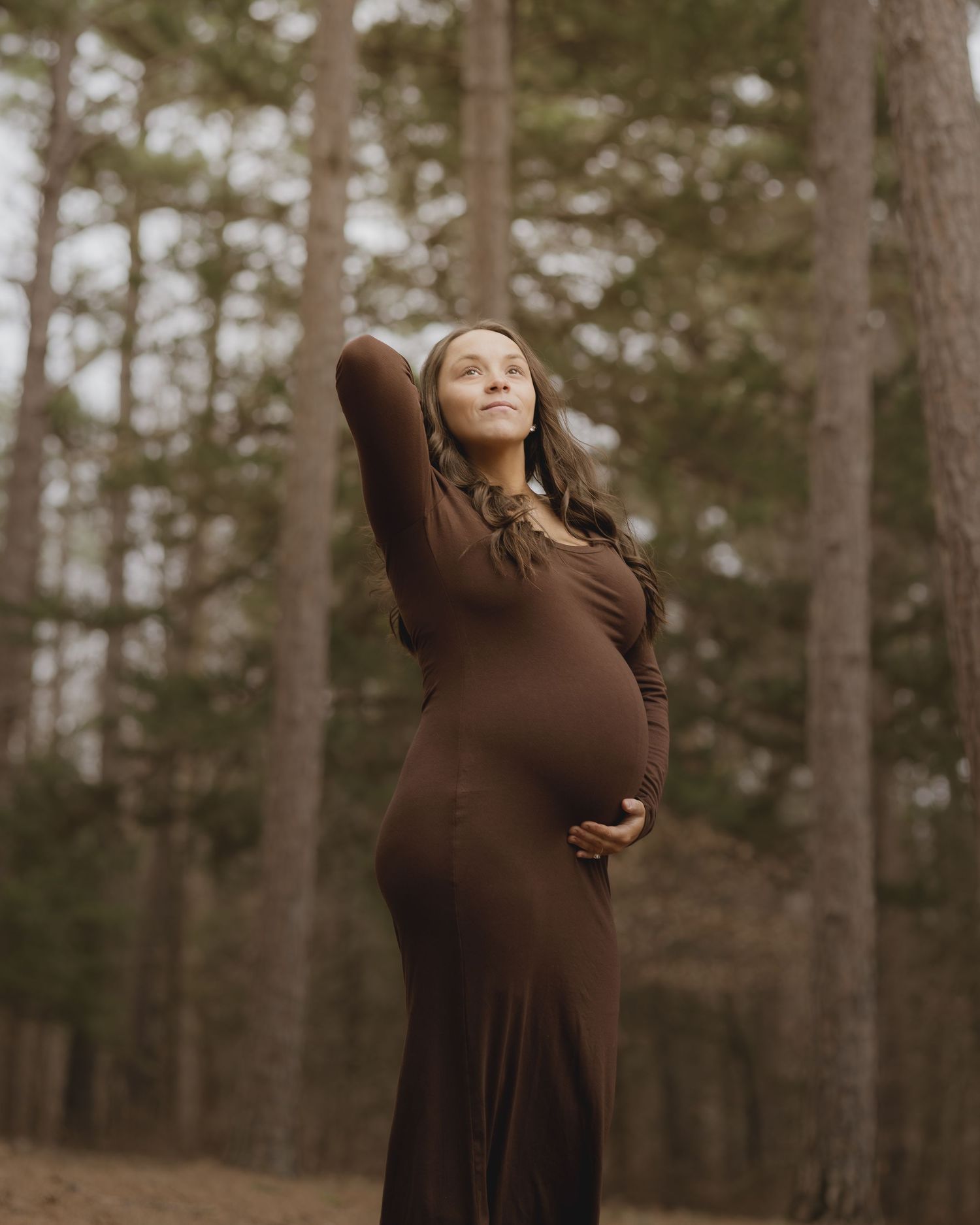 A series of artistic maternity portraits showing a woman in a brown dress against a wooded forest background.