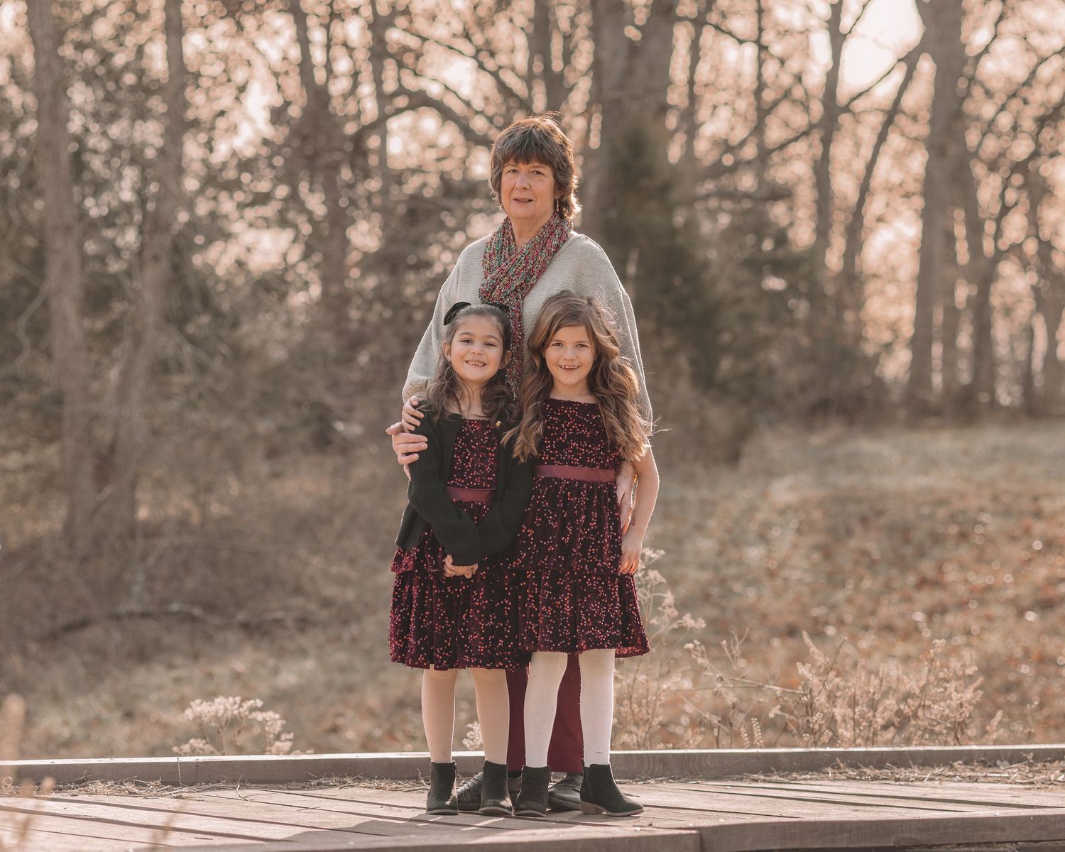 Family members arranged in casual poses against a backdrop of fall trees.