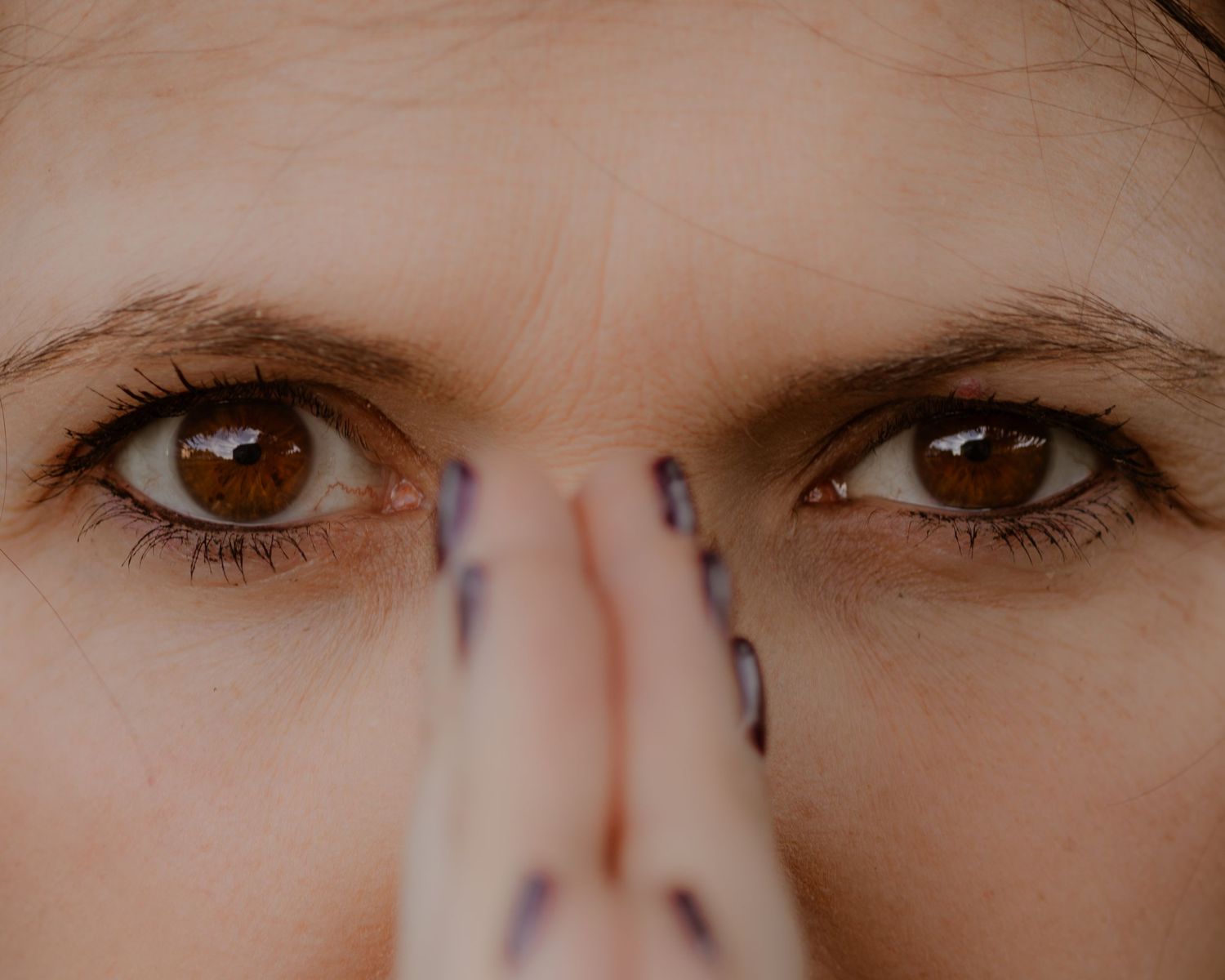 Extreme close-up of eyes with artistic markings near the eyebrows.