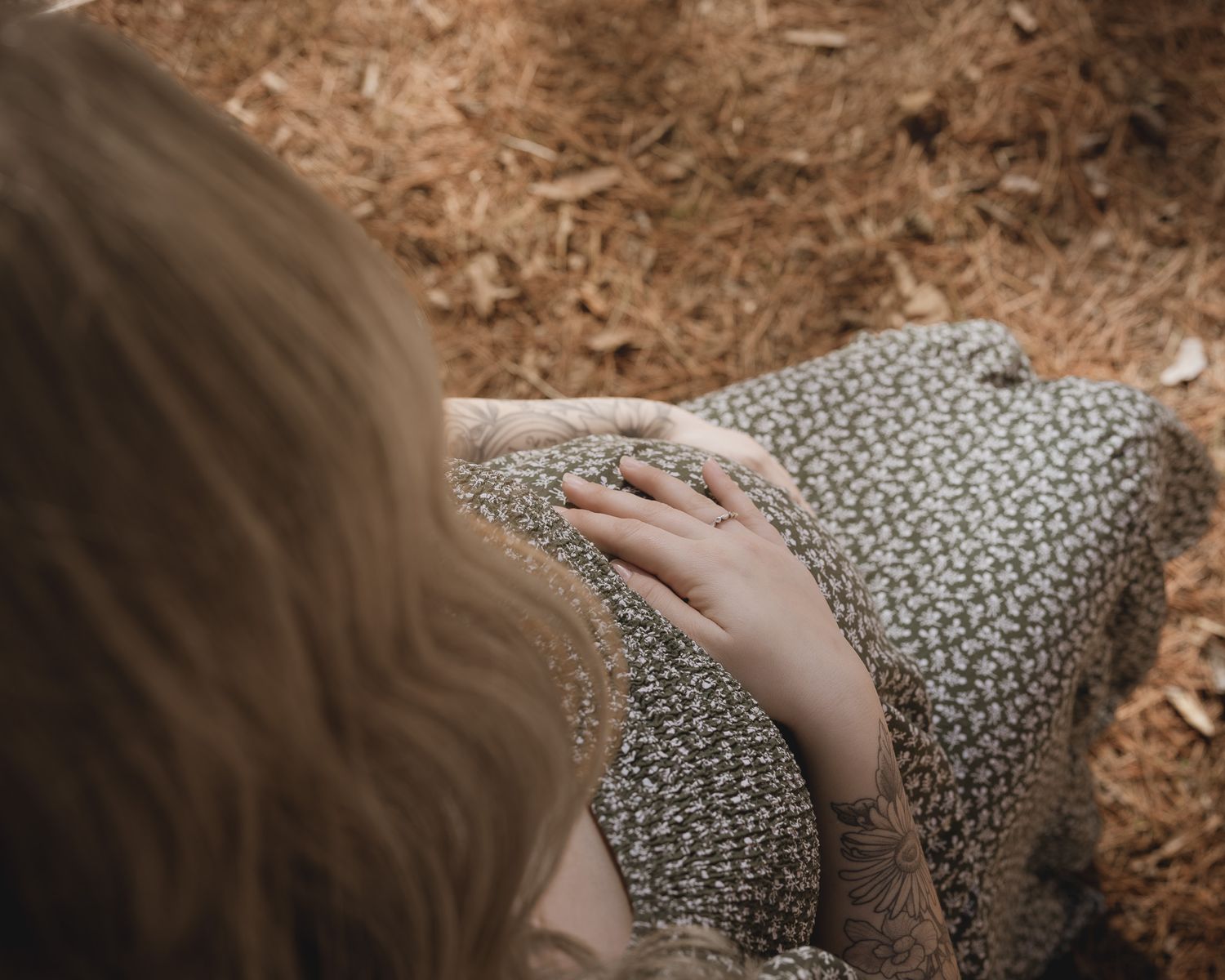 A hand gently touches a textured surface covered in small floral patterns.