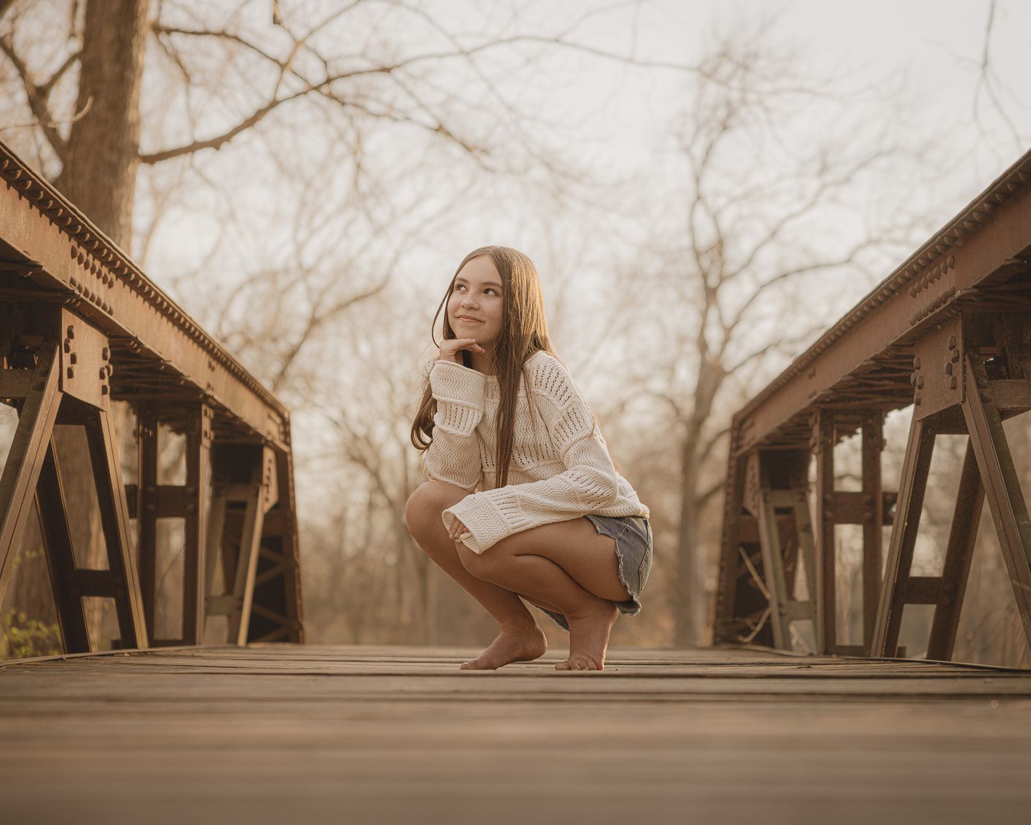 Sepia toned photos on rustic wooden bridge showing different sitting poses and angles.