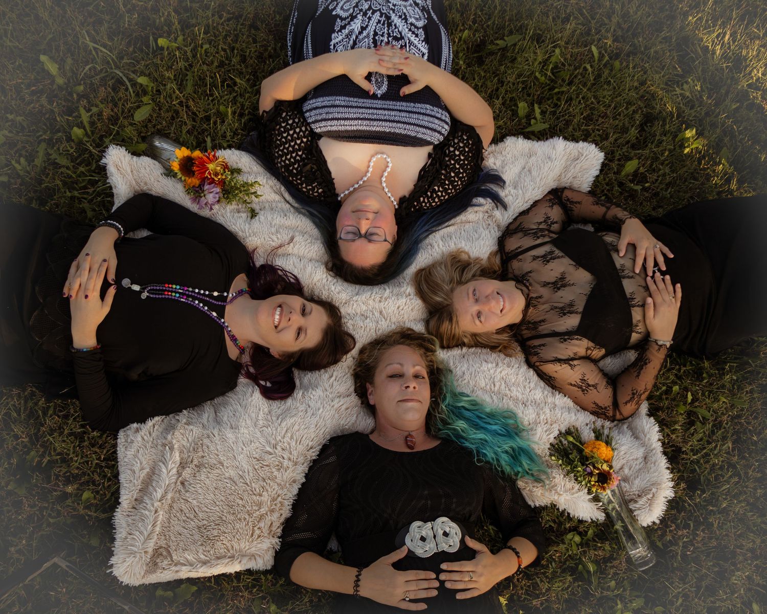 Aerial view of people lying on the ground in formal attire creating an artistic composition with flowers.