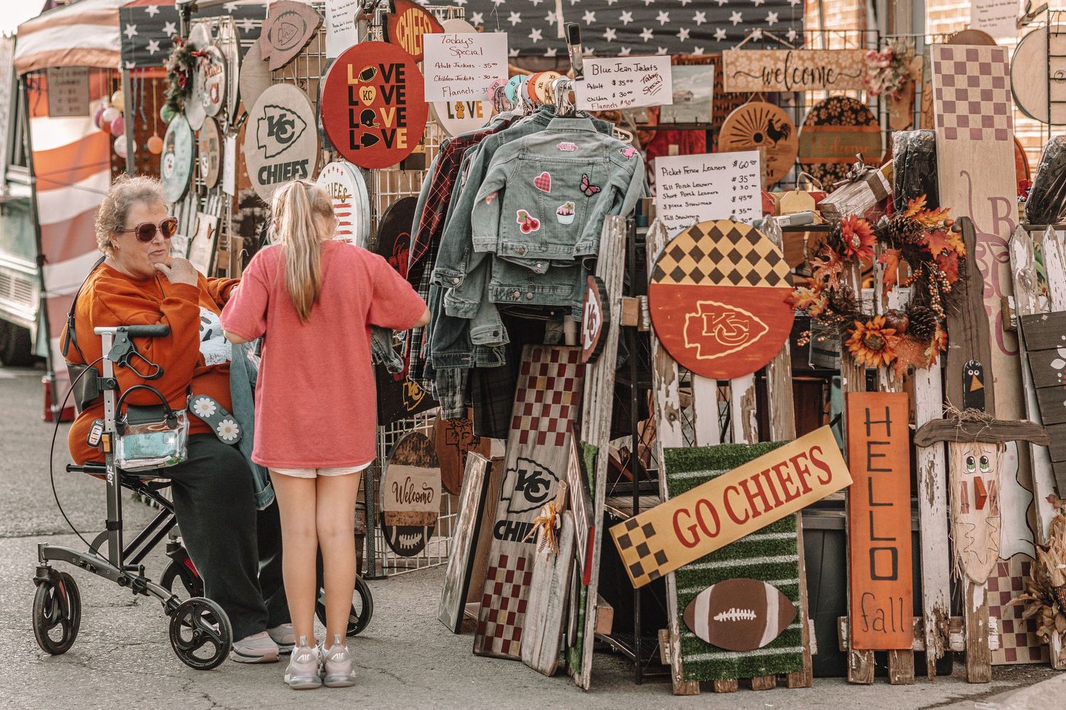 Row of colorful vendor booths and stalls at an outdoor market with vintage-style decorations.