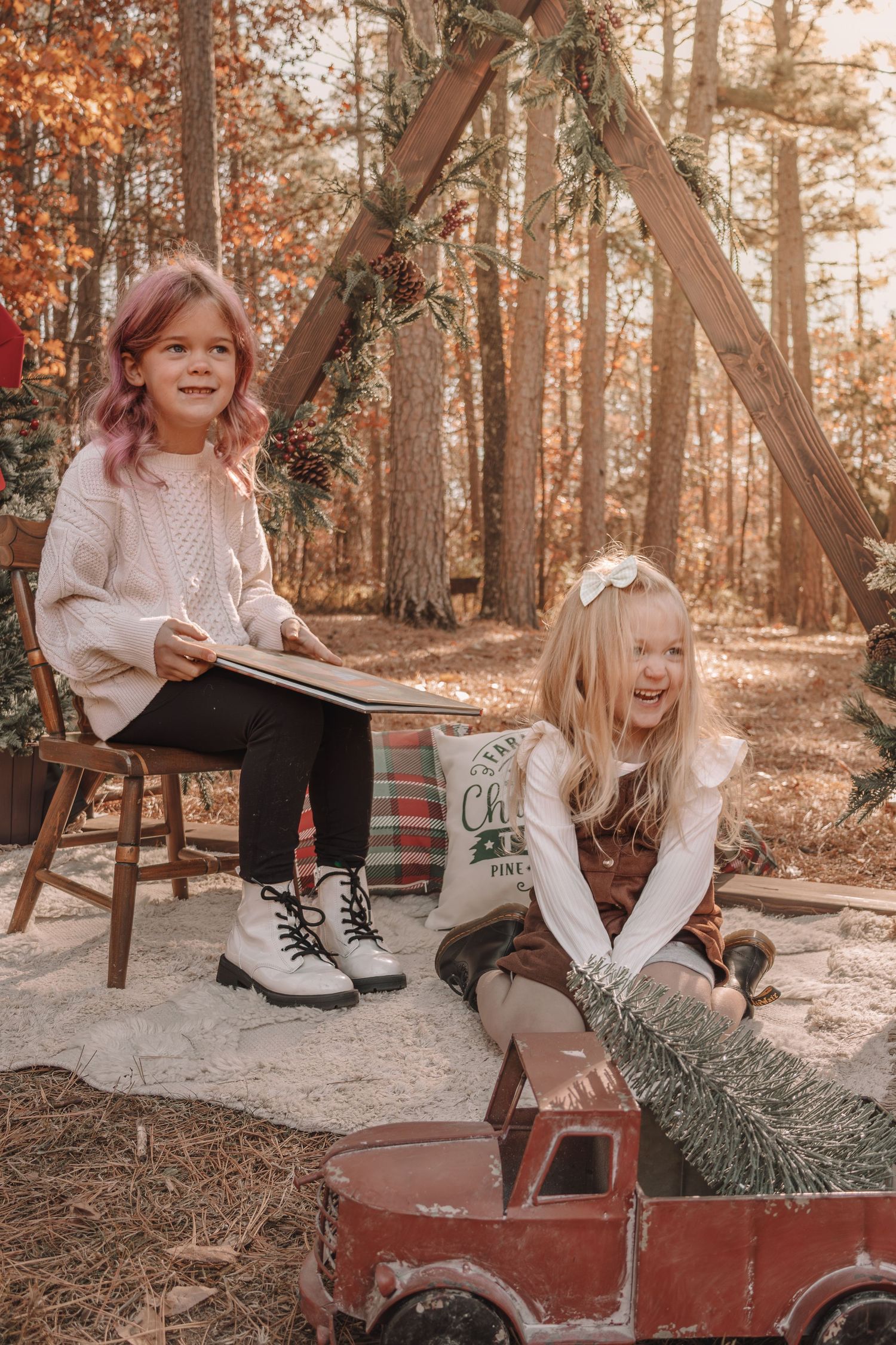 Children play and laugh together in a rustic outdoor setting with warm autumn lighting and a vintage red wagon.