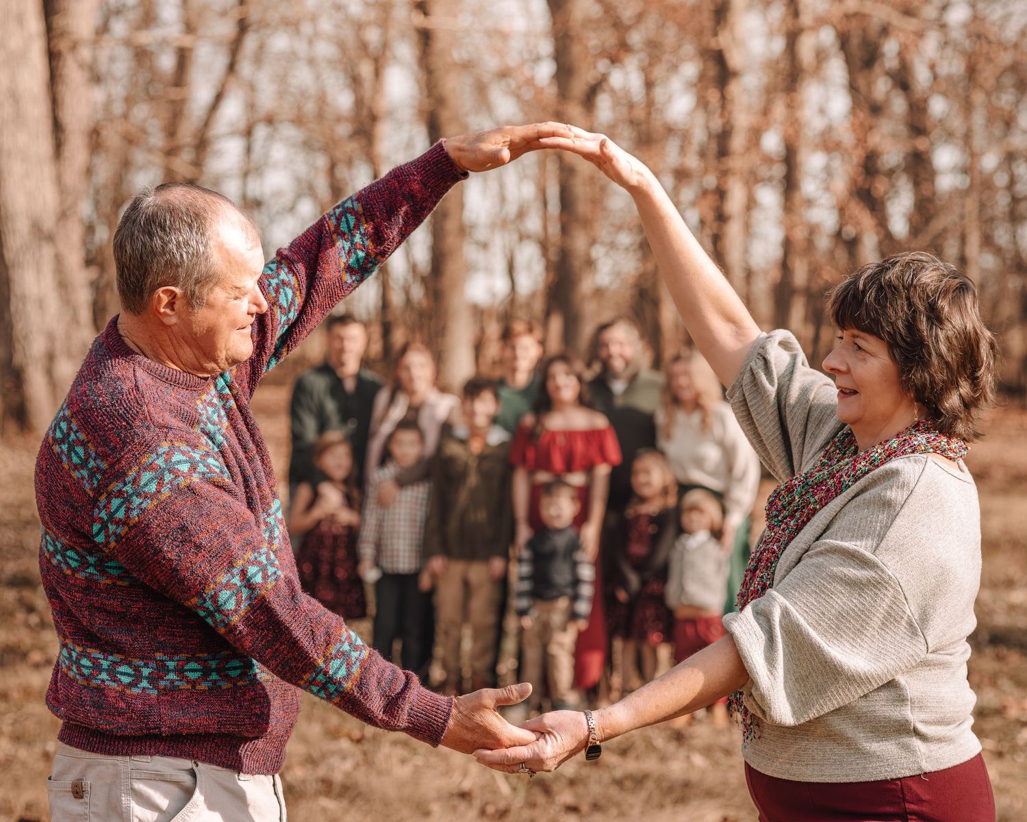Candid dancing moments captured between family members in an autumn forest setting.
