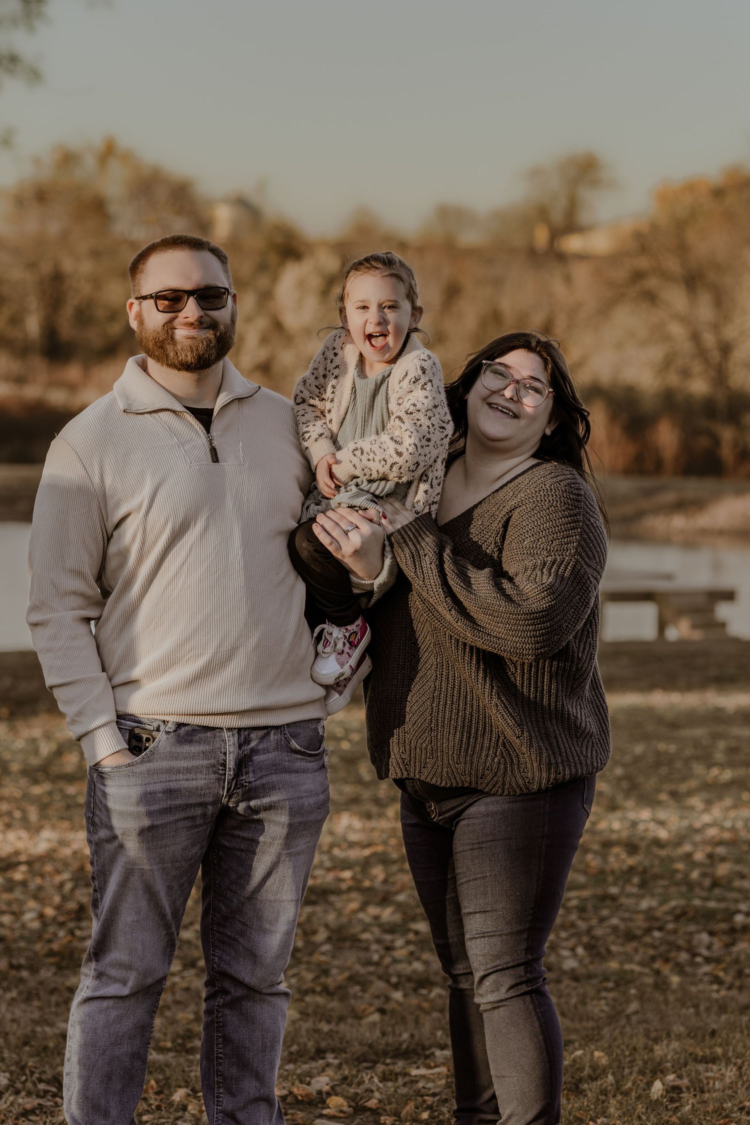 A family shares joyful moments together in a park during golden hour.
