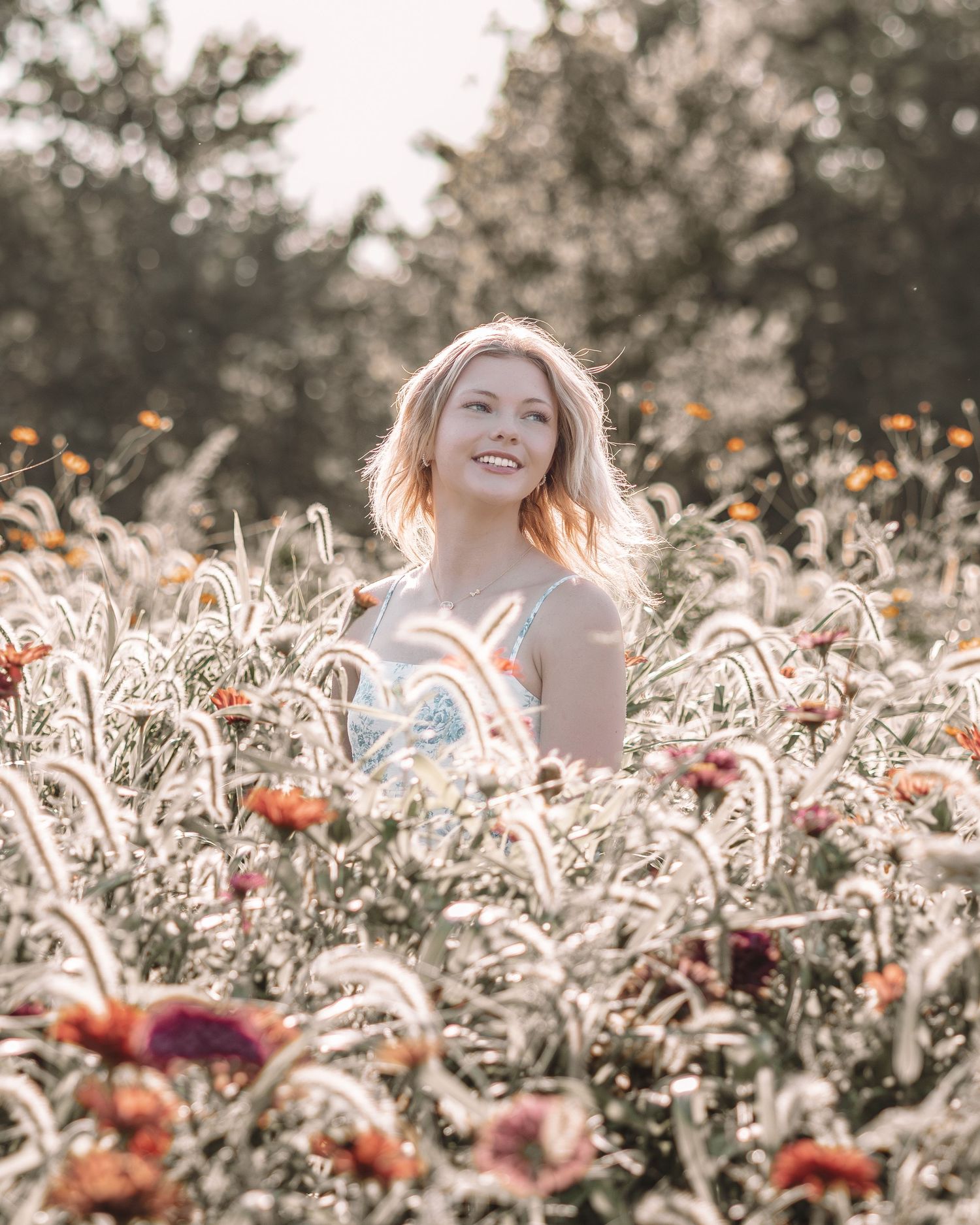 Ethereal outdoor portrait surrounded by delicate white flowers and vibrant red blooms.