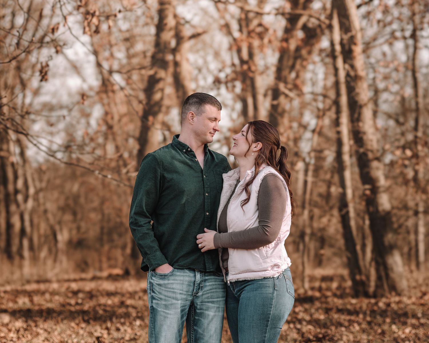 Intimate couple portrait with natural poses in a wooded autumn setting.