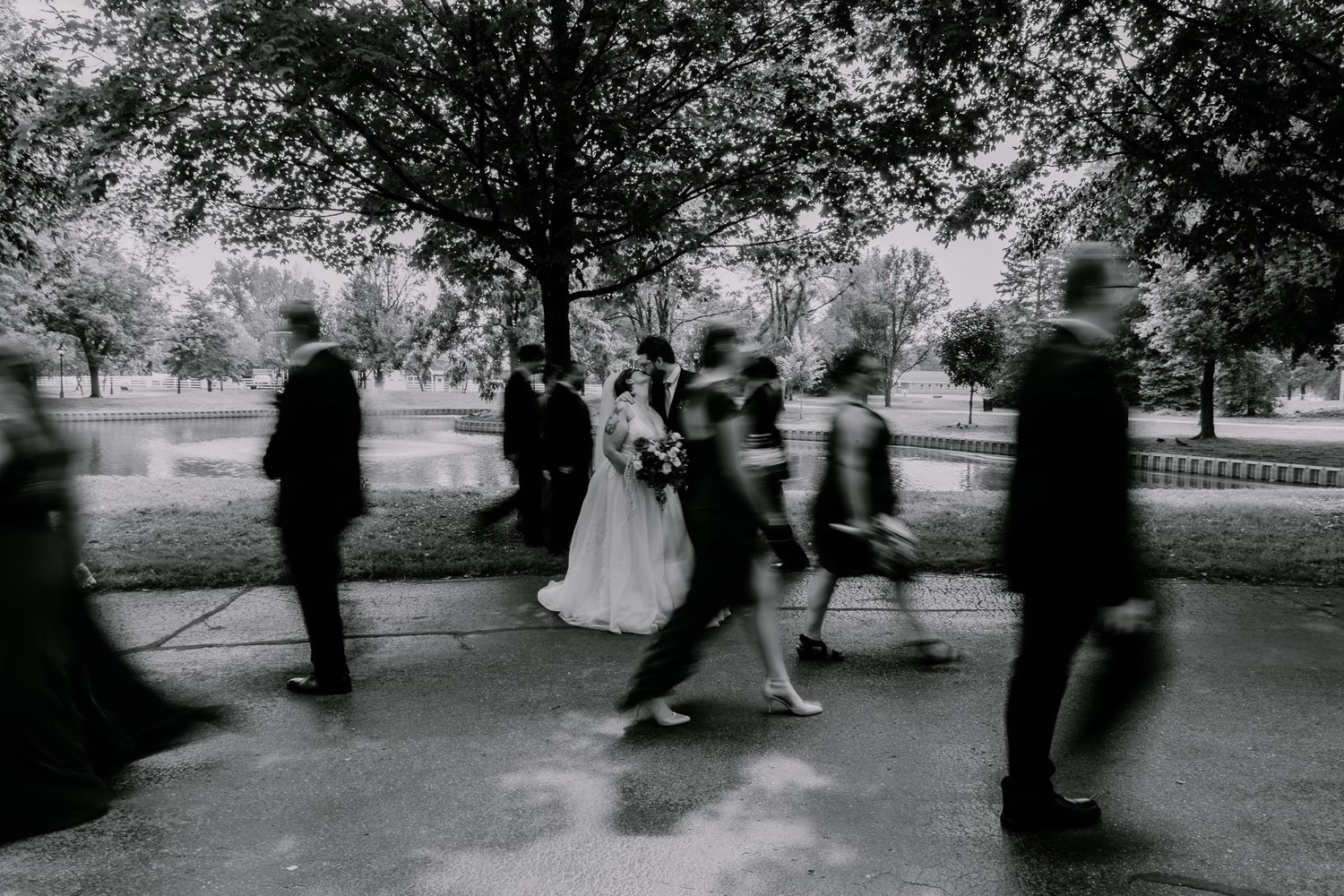 Black and white motion blur photo showing people walking outdoors.