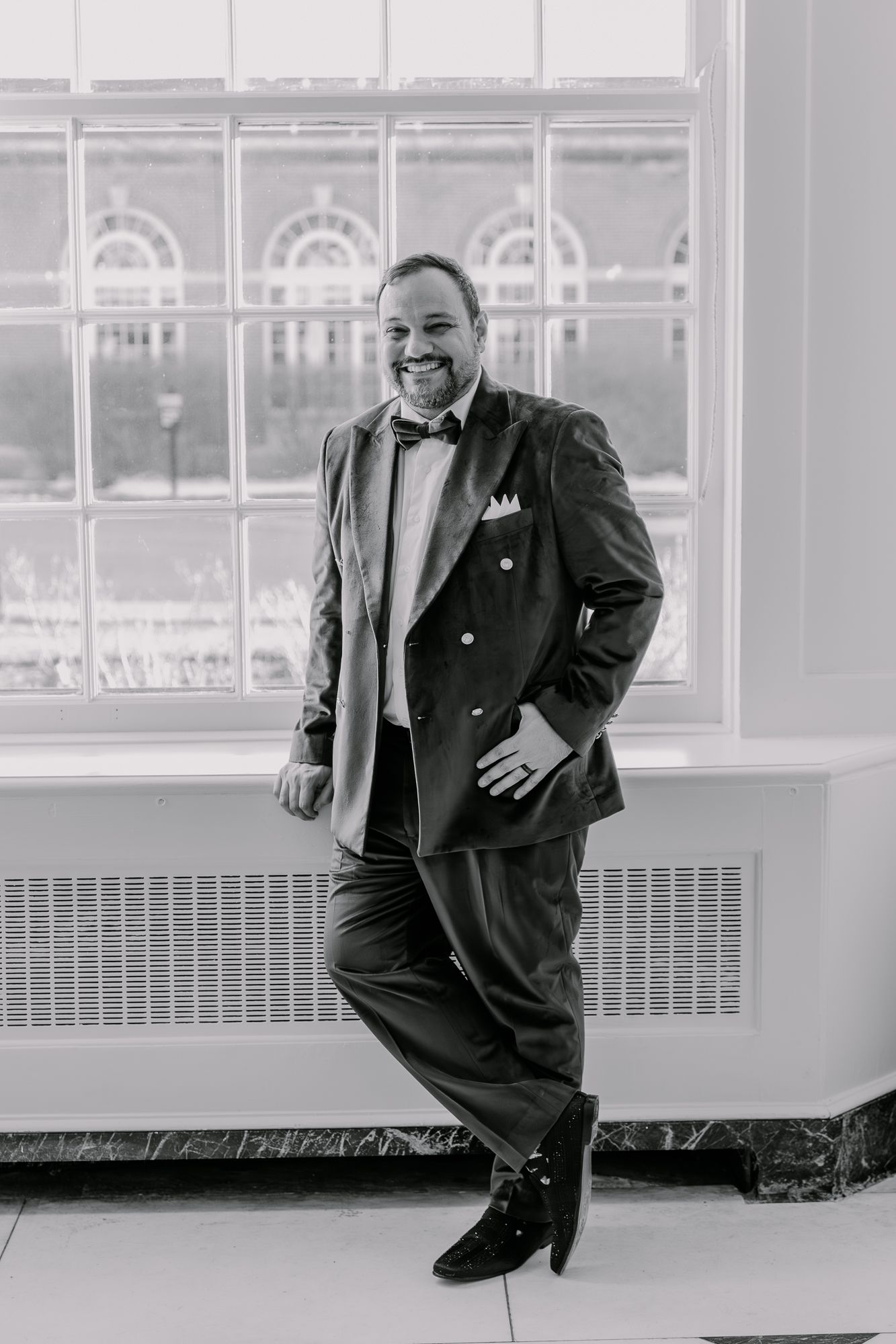 Artistic black and white series showing a dark suit against bright interior space.