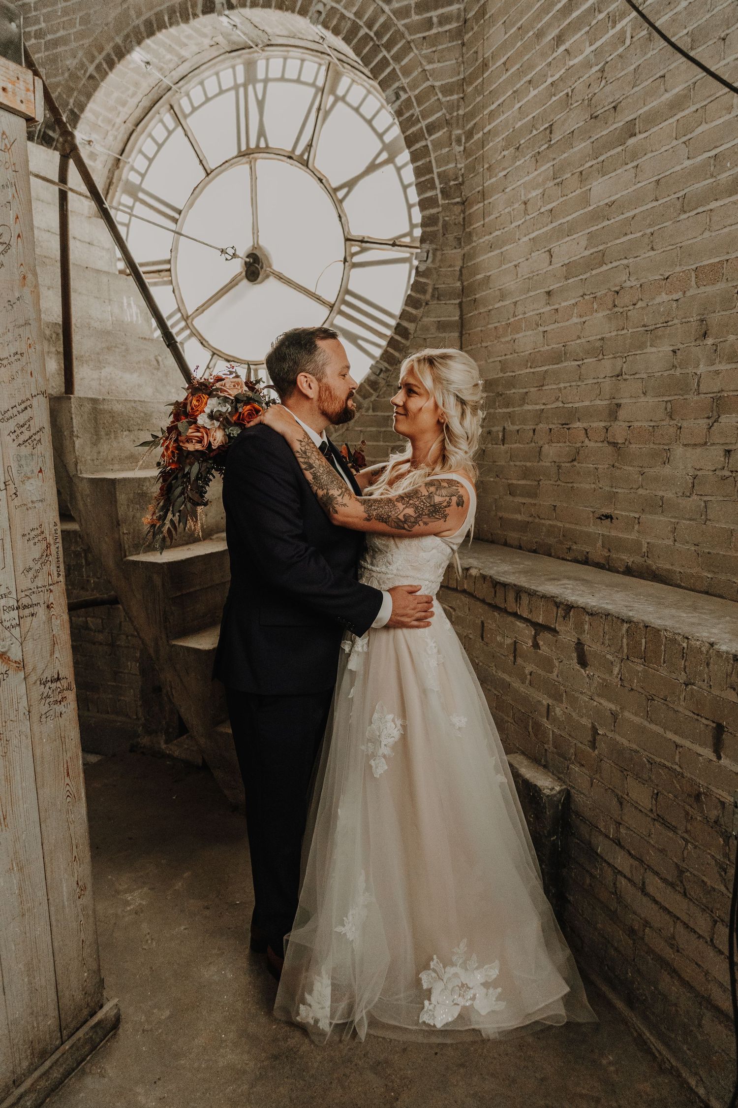 A romantic couple dances together in a rustic brick tunnel during their wedding celebration.