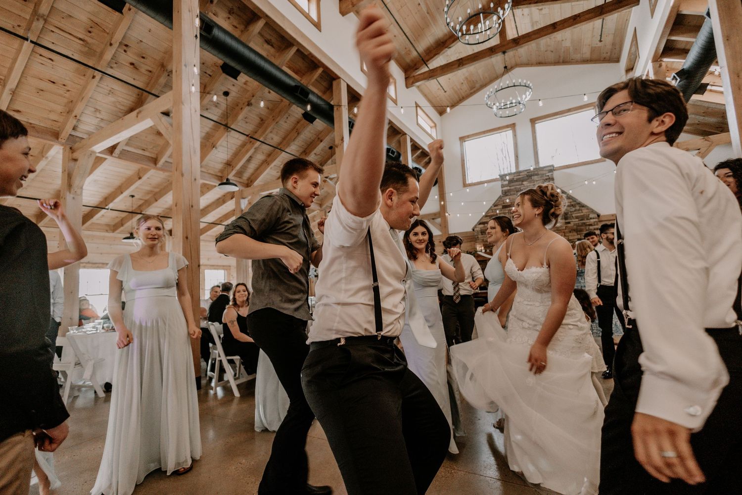 Guests dancing and celebrating at a rustic barn wedding reception.