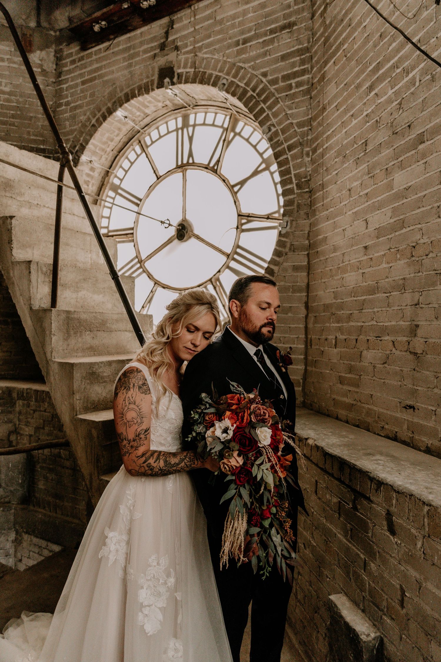 A series of romantic wedding photos featuring a couple posing against a brick wall with vintage clock faces.