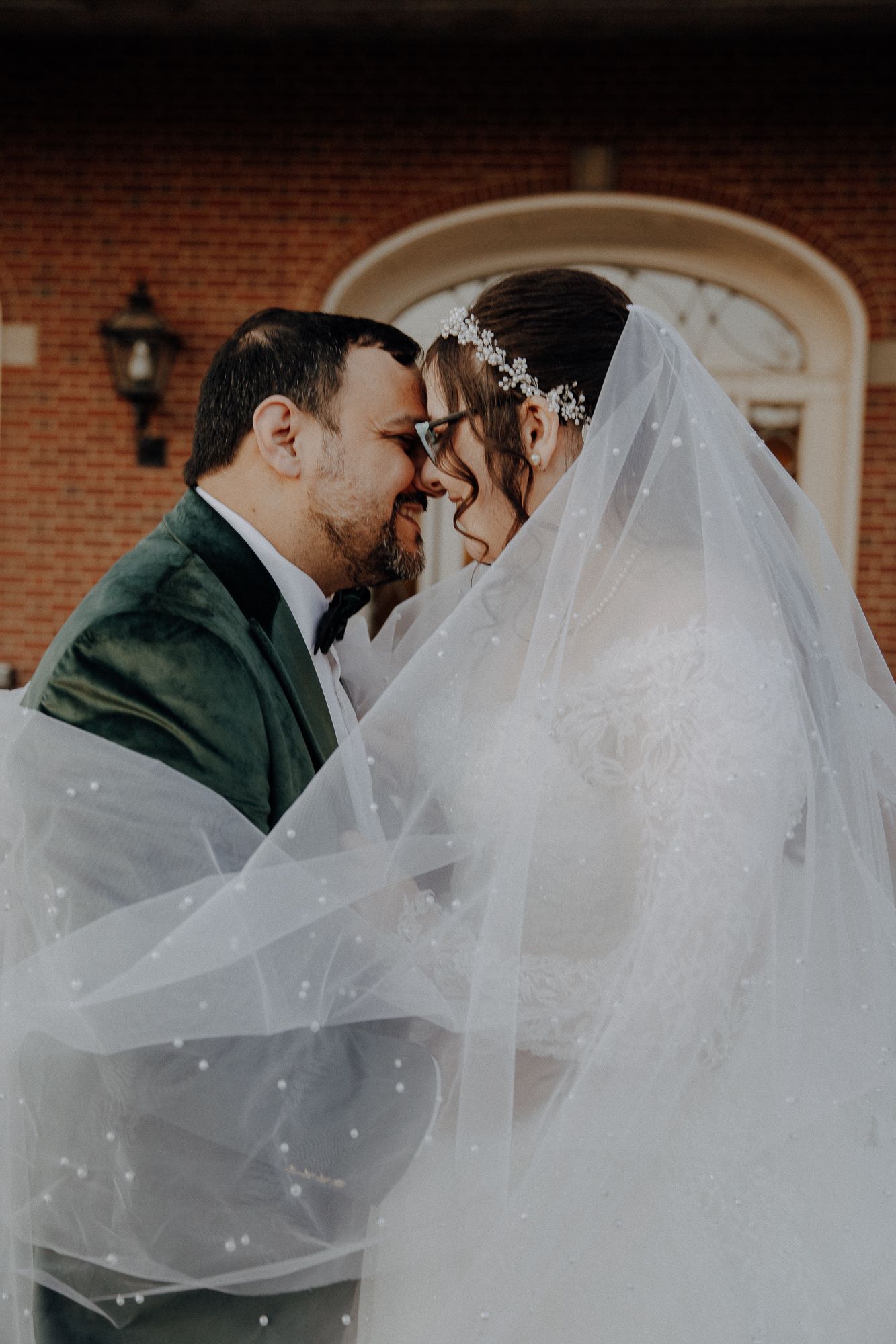 Dreamy wedding photography sequence with flowing veil against brick architecture.