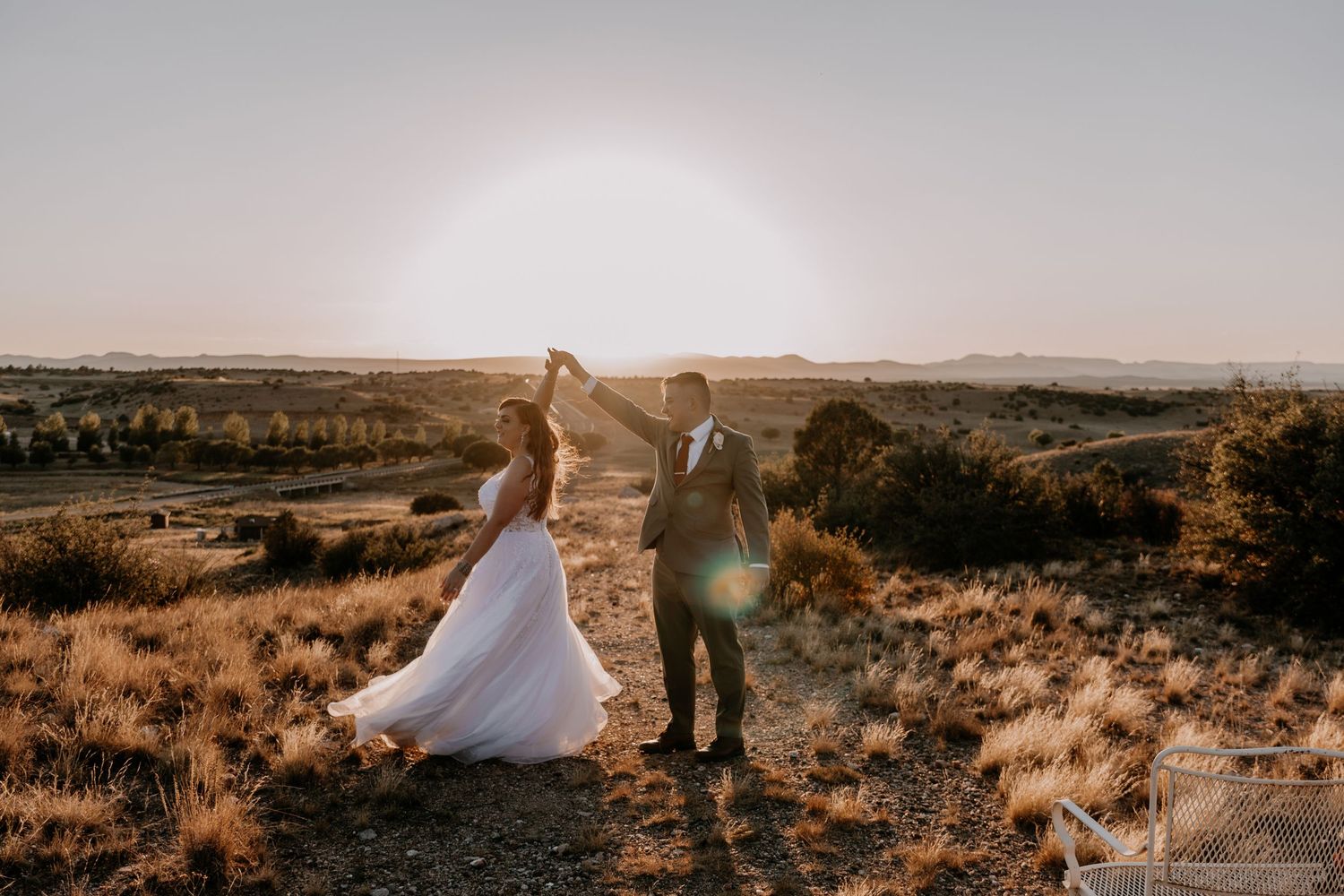 Desert wedding portrait with dramatic sunset lighting and vast landscape views.
