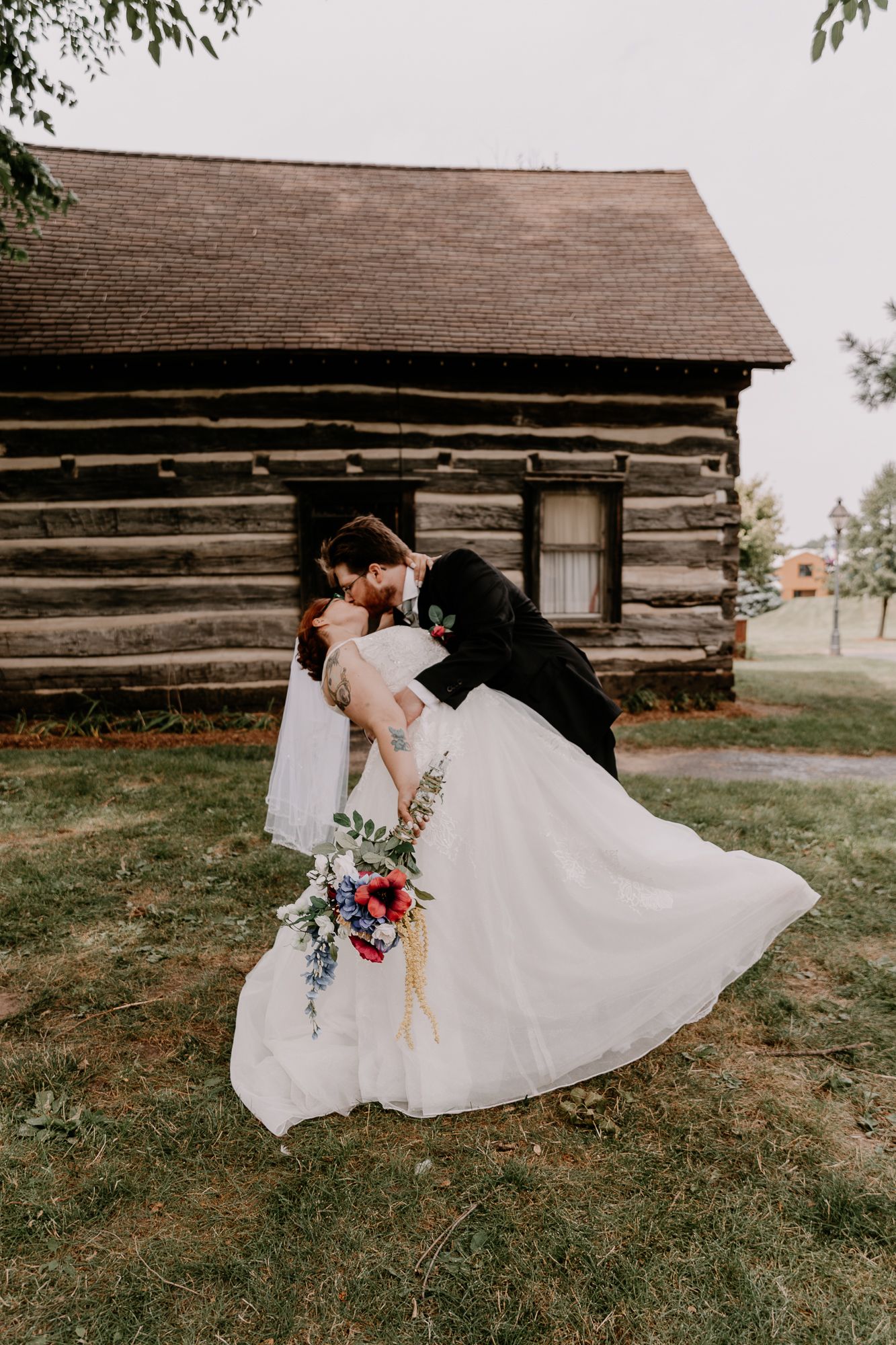 Romantic wedding photo session in front of rustic log cabin.